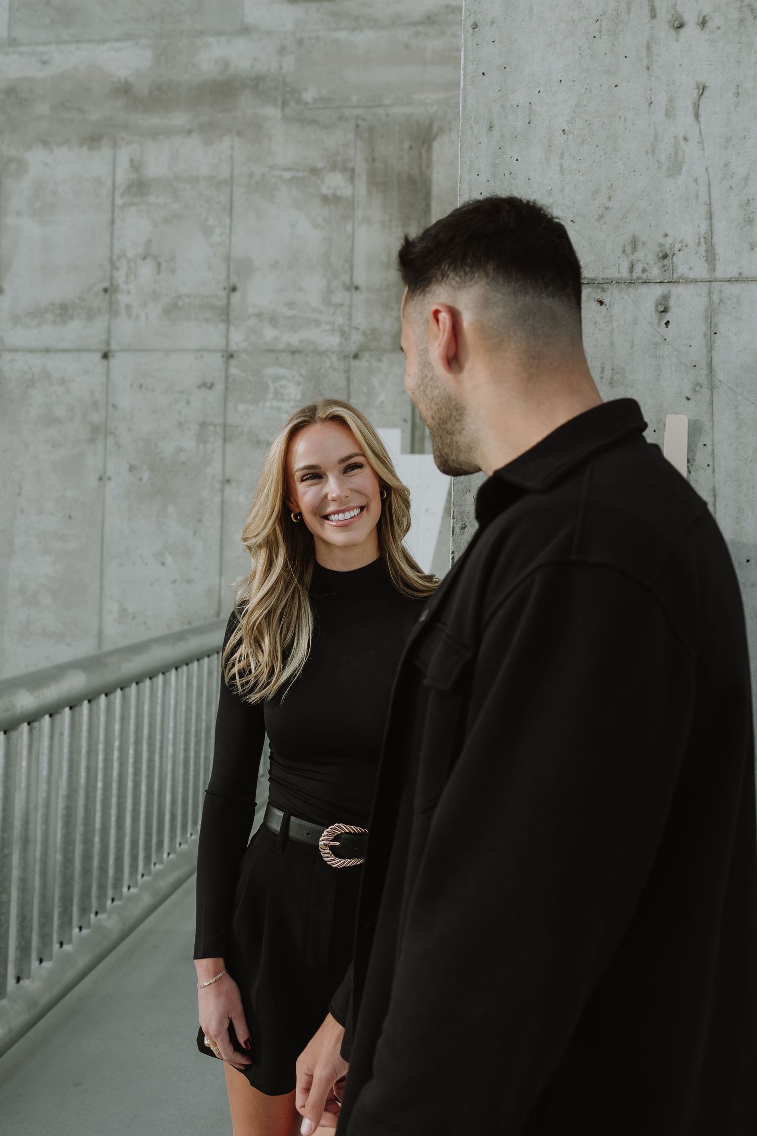 Calgary engagement photographer capturing a couple in downtown’s urban scenery with relaxed, authentic storytelling style