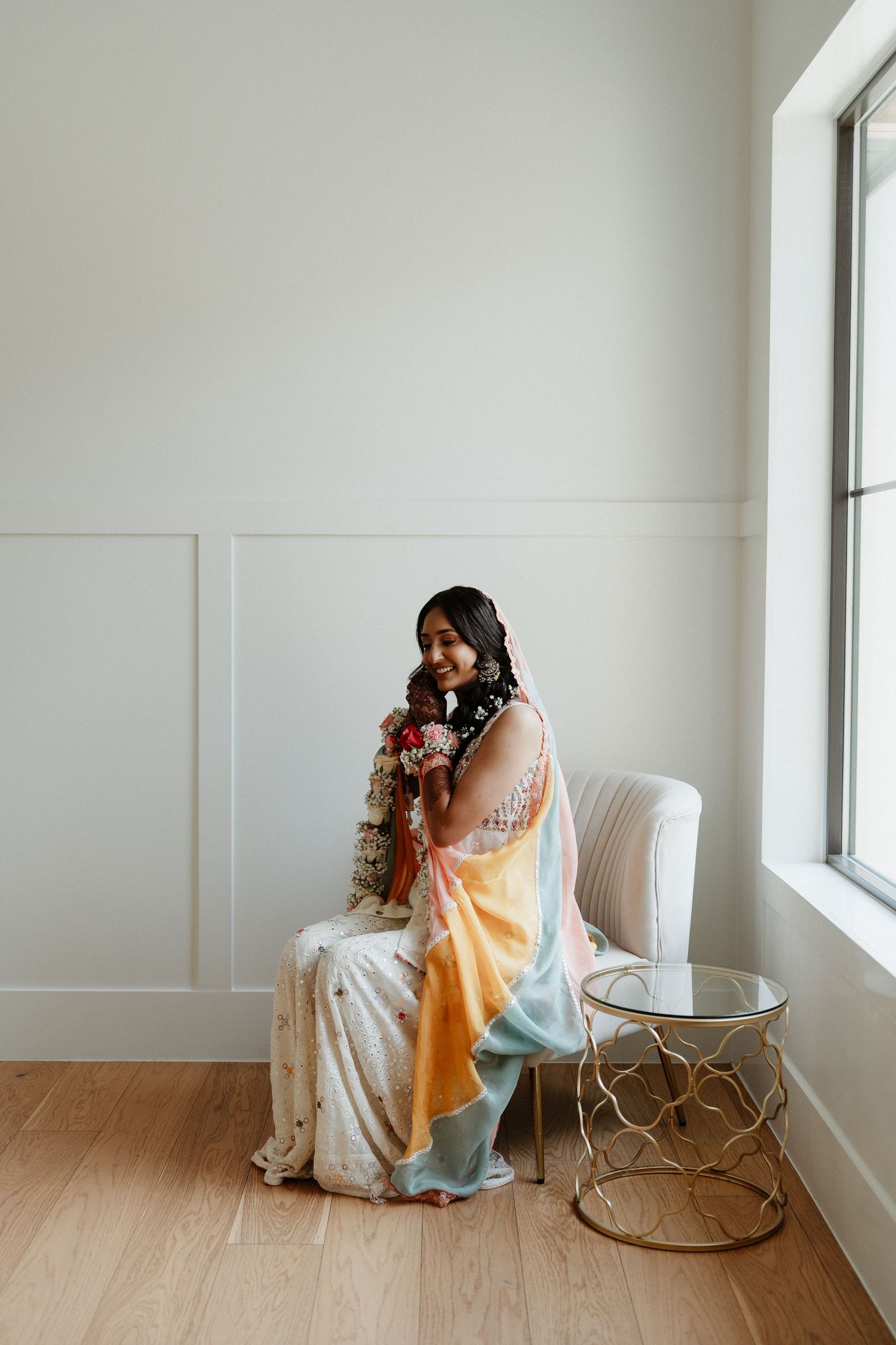 A series of three photos showing a person in a flowy dress sitting in a white chair next to a gold accent table.