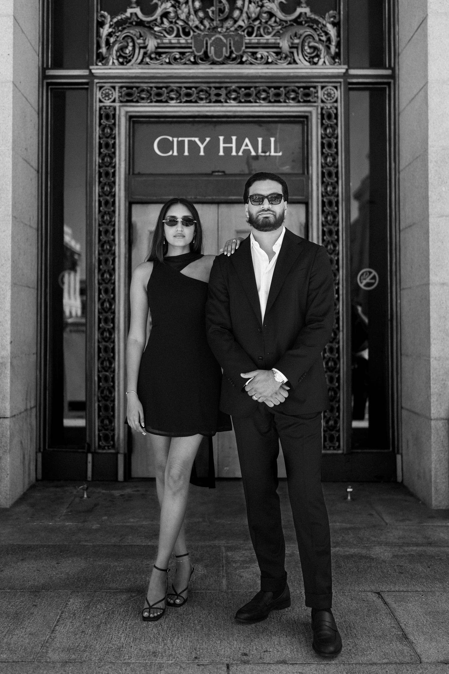 A stylish couple stands in front of San Francisco City Hall in a black and white artistic photo series.