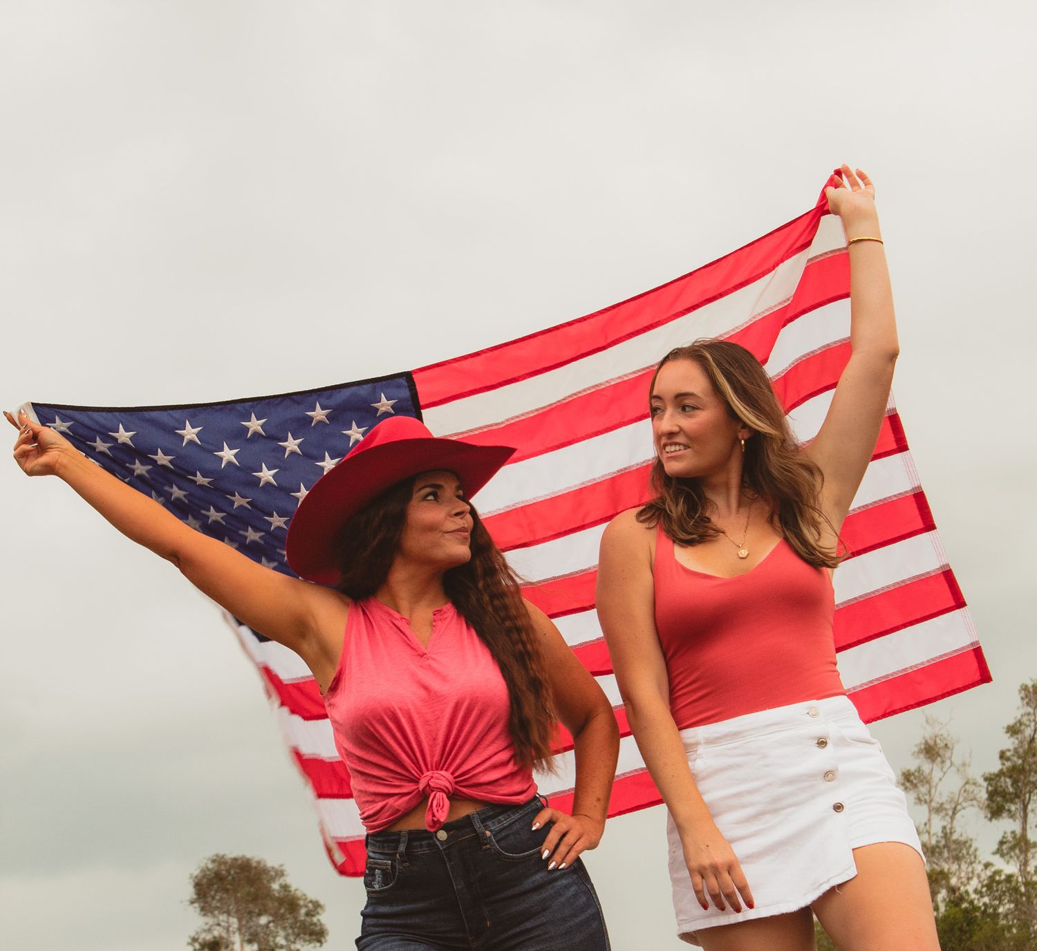 a portrait of two women holding up a flag