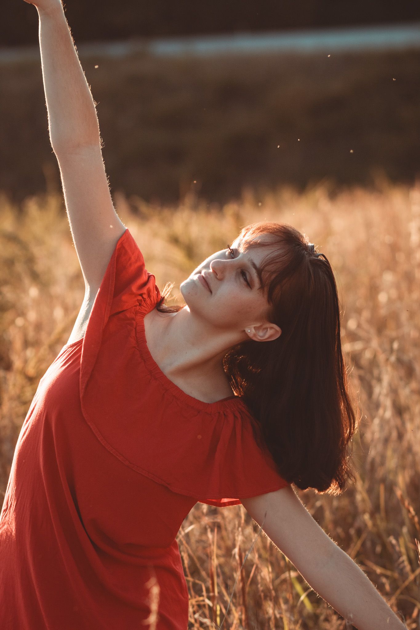 a portrait of a woman dancing in a field