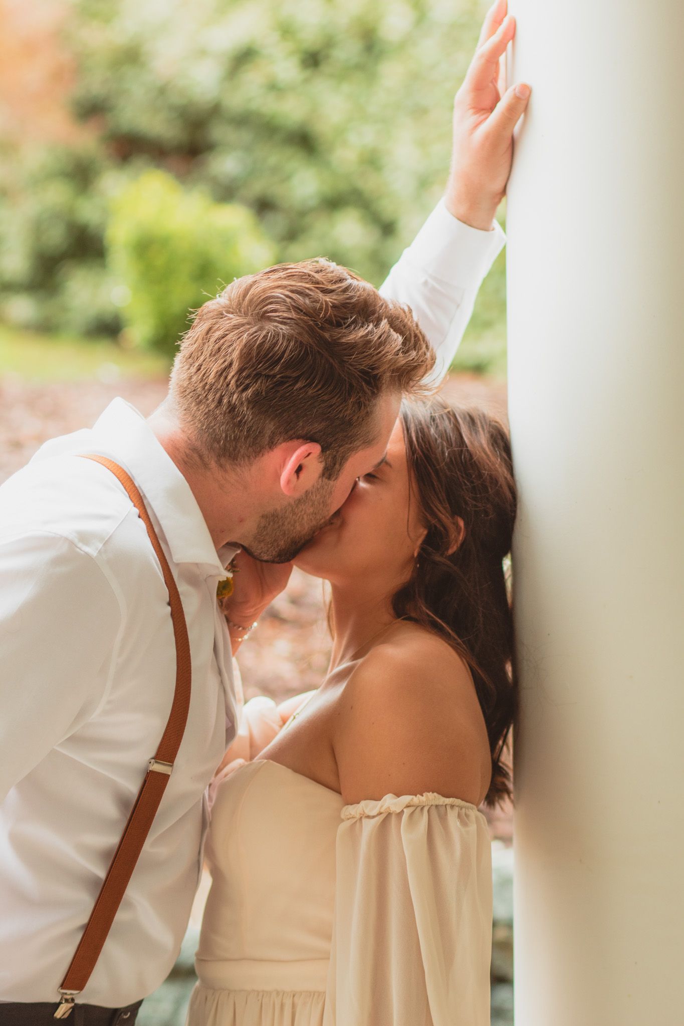 a portrait of a groom kissing his bride