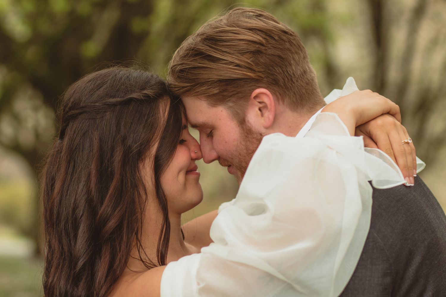a portrait of a bride and groom touching foreheads