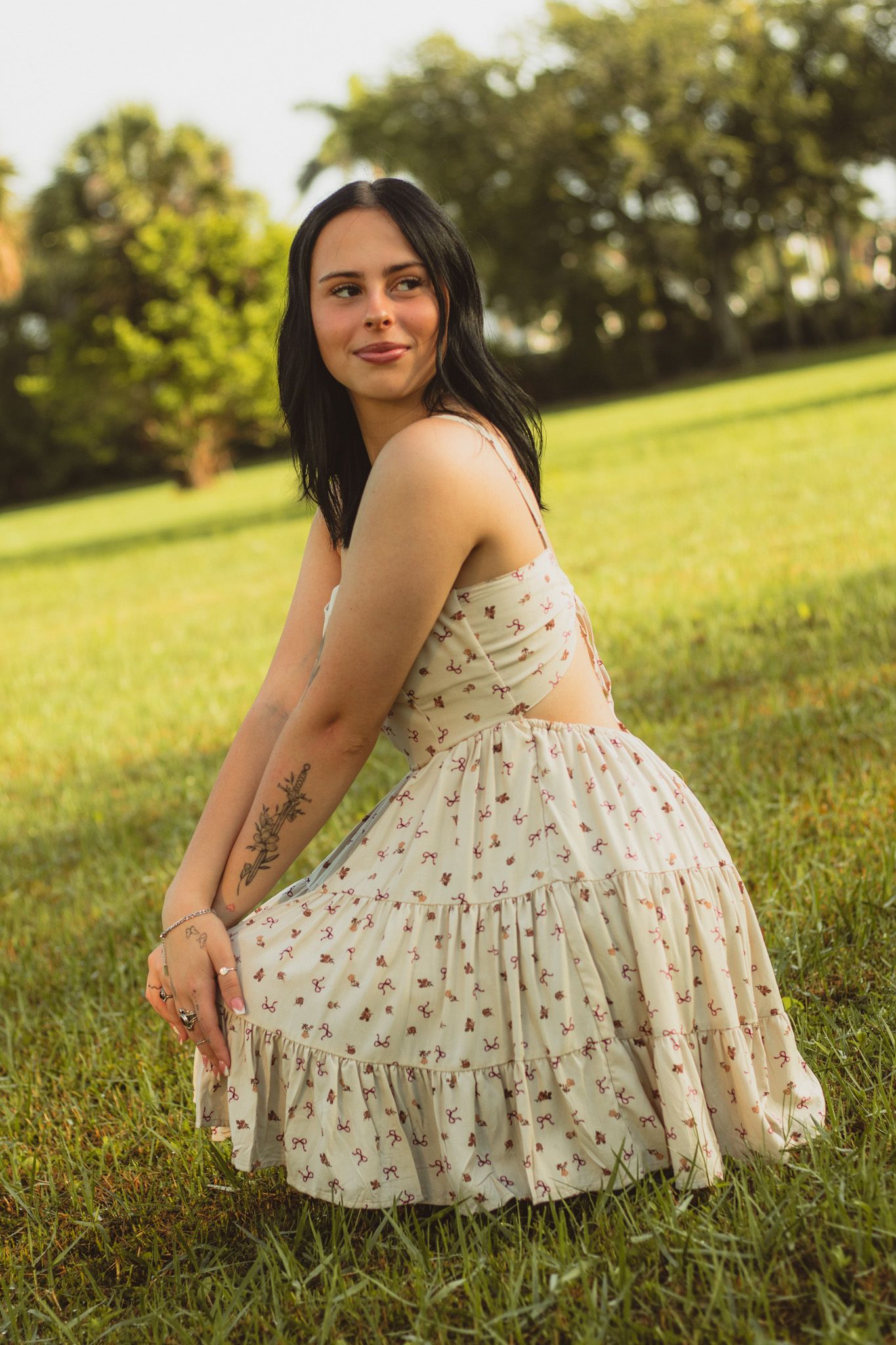 portrait of a young woman kneeling in a field