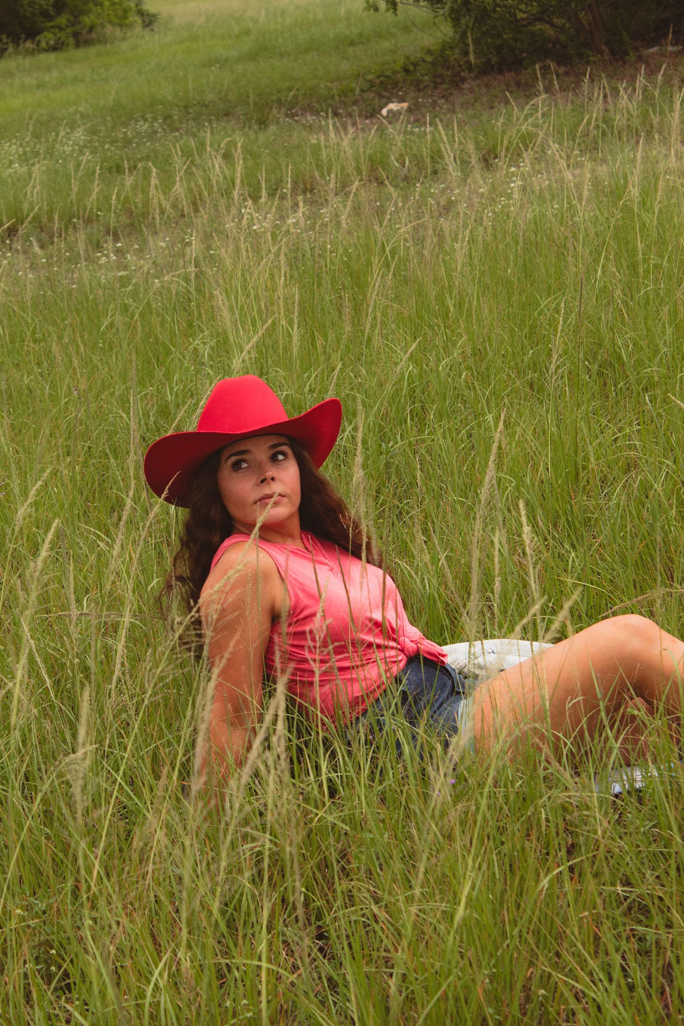 a portrait of a woman sitting in the grass
