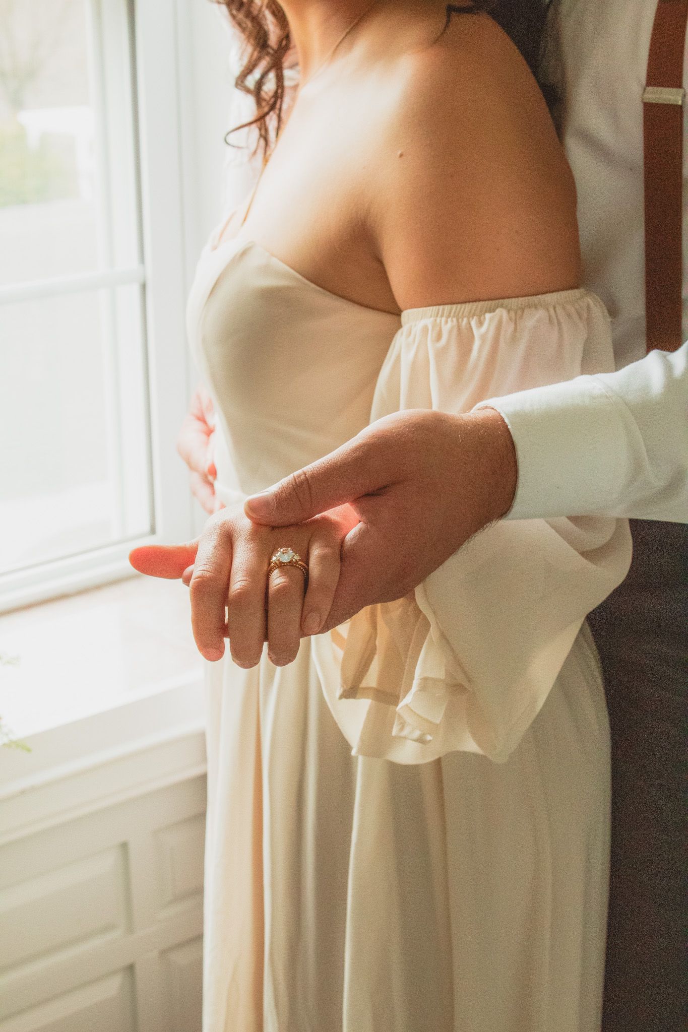portrait of a groom holding out the hand of his bride