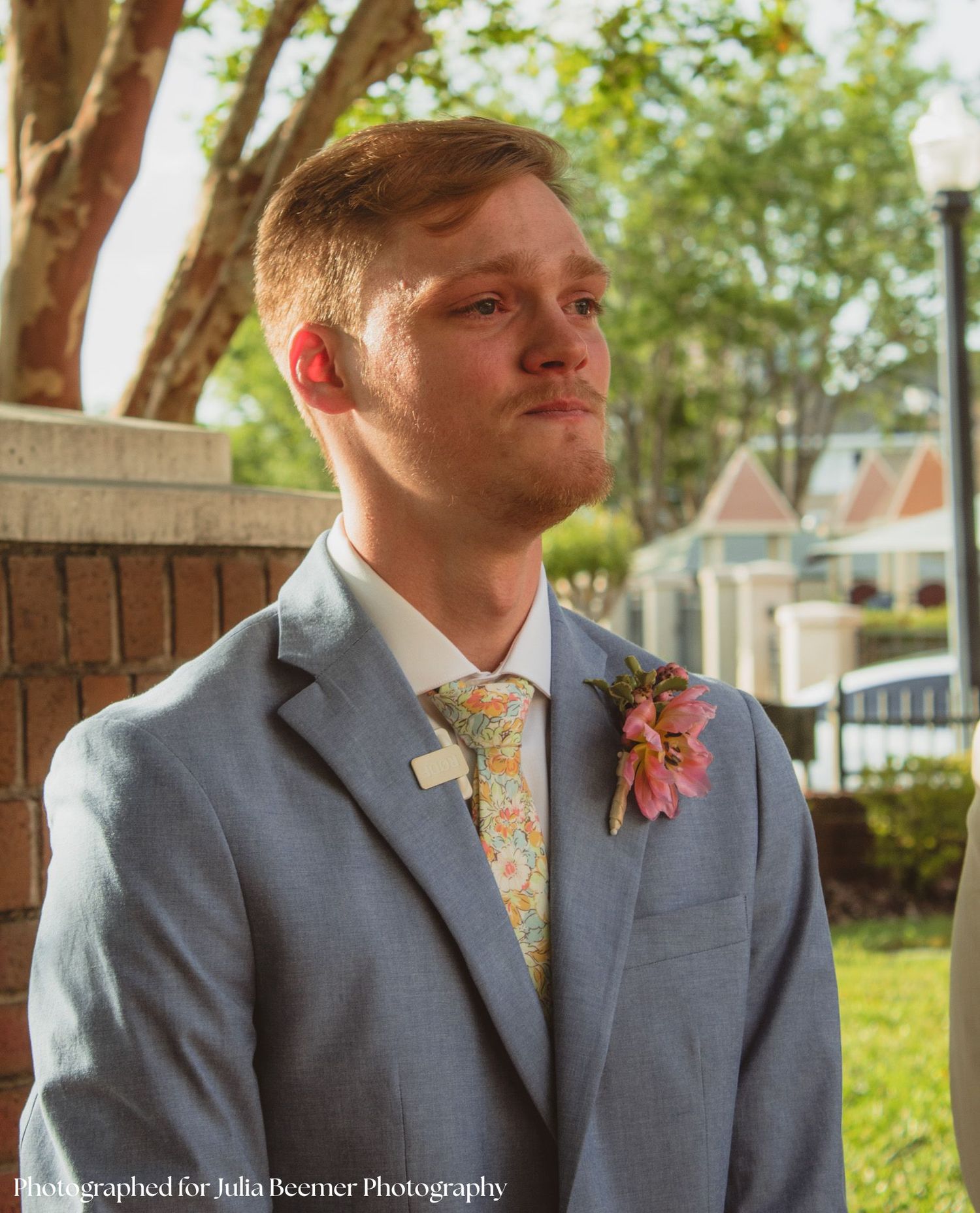 a portrait of a groom tearfully looking at his bride