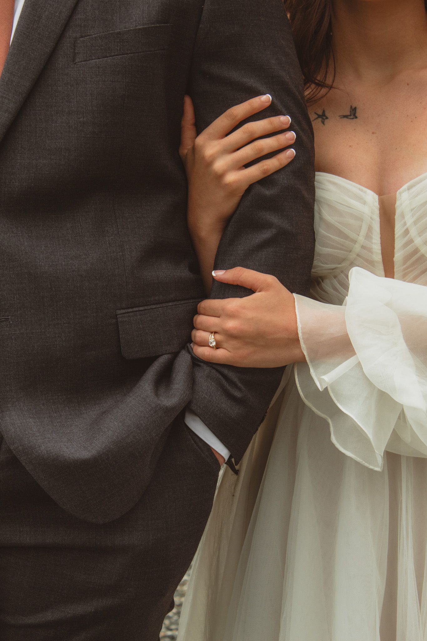 a portrait of a bride's hands wrapped around her groom's arms