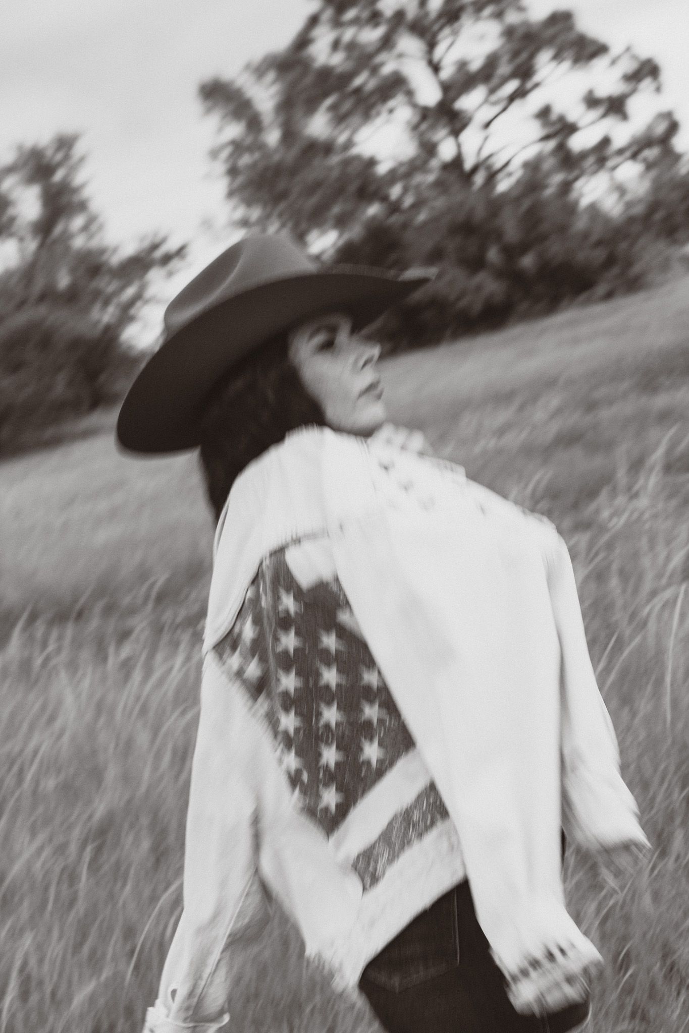 a black and white portrait of a young woman in a cowboy hat