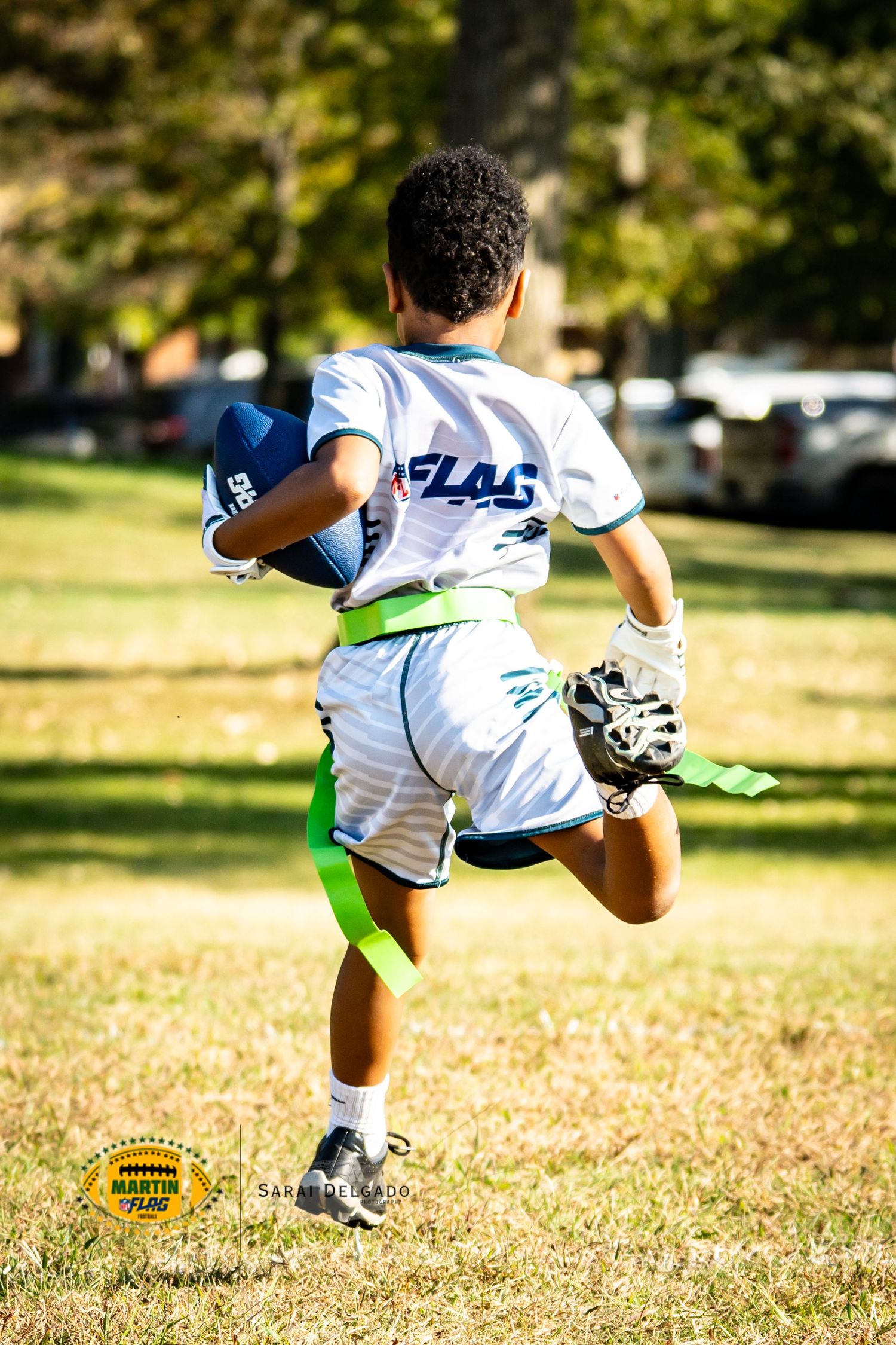 Action sequence shows a player diving and falling during a flag football match on a sunny autumn field.