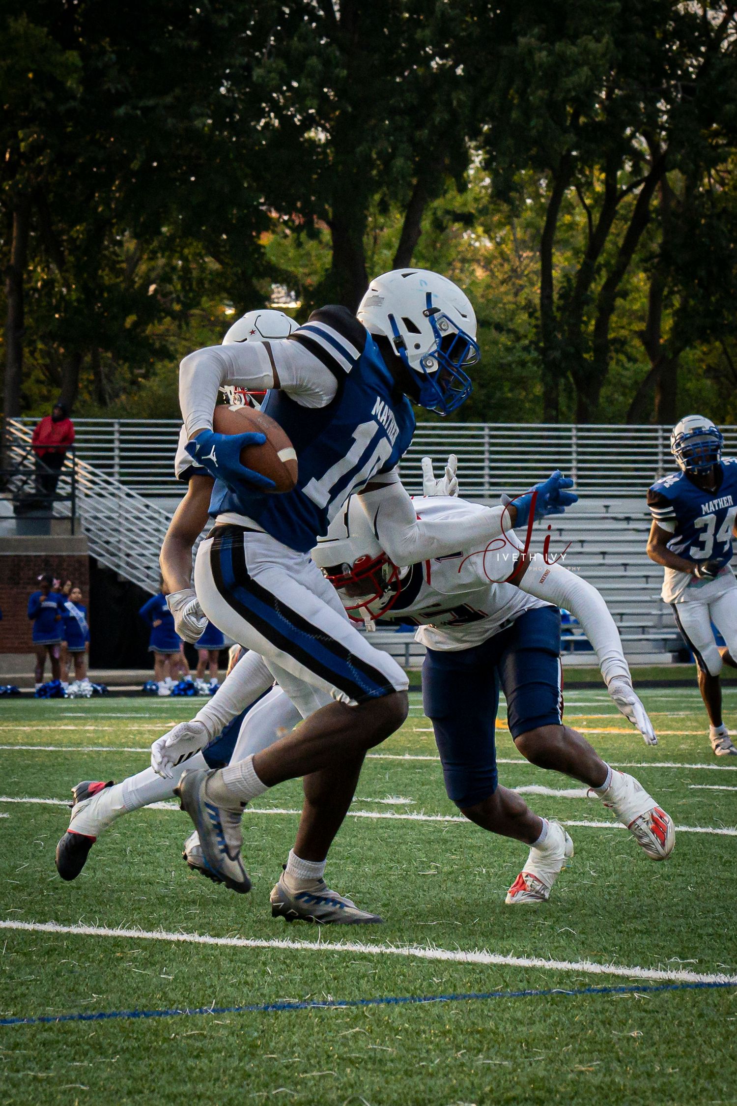 Football players in white and blue uniforms engage in an intense line of scrimmage during a game.
