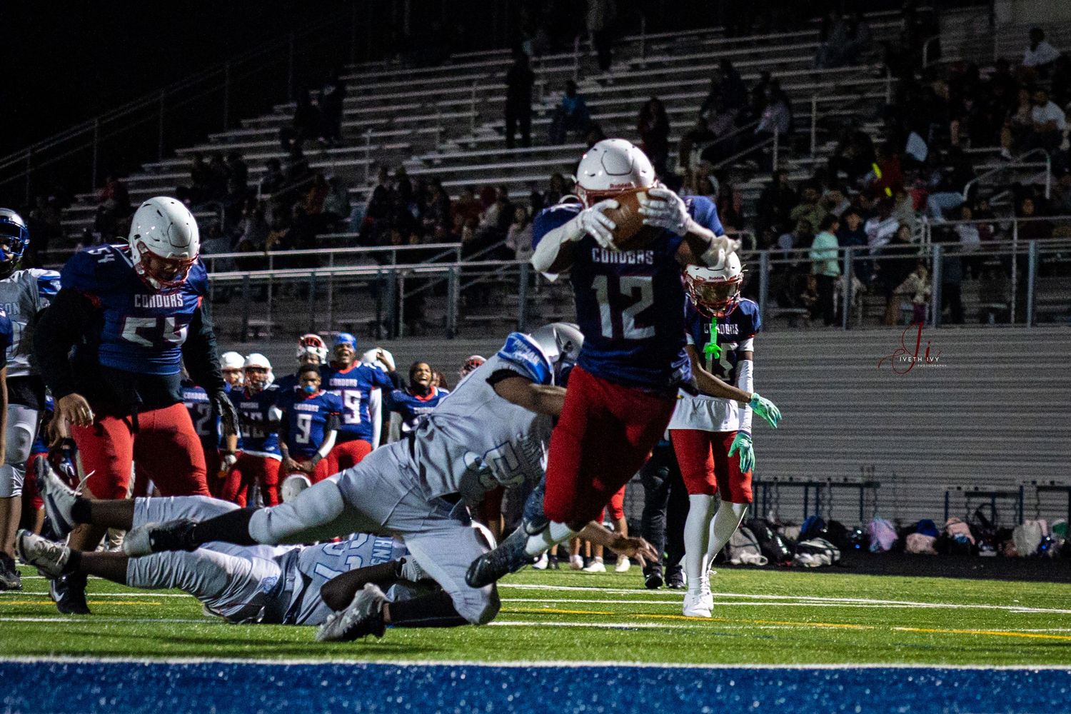 Football players collide on the field during an intense tackle play in a professional match.