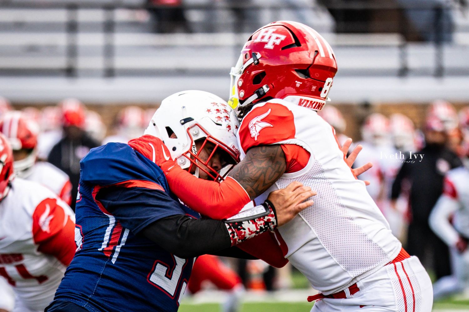 Football players engage in intense blocking drills during practice session on the field.