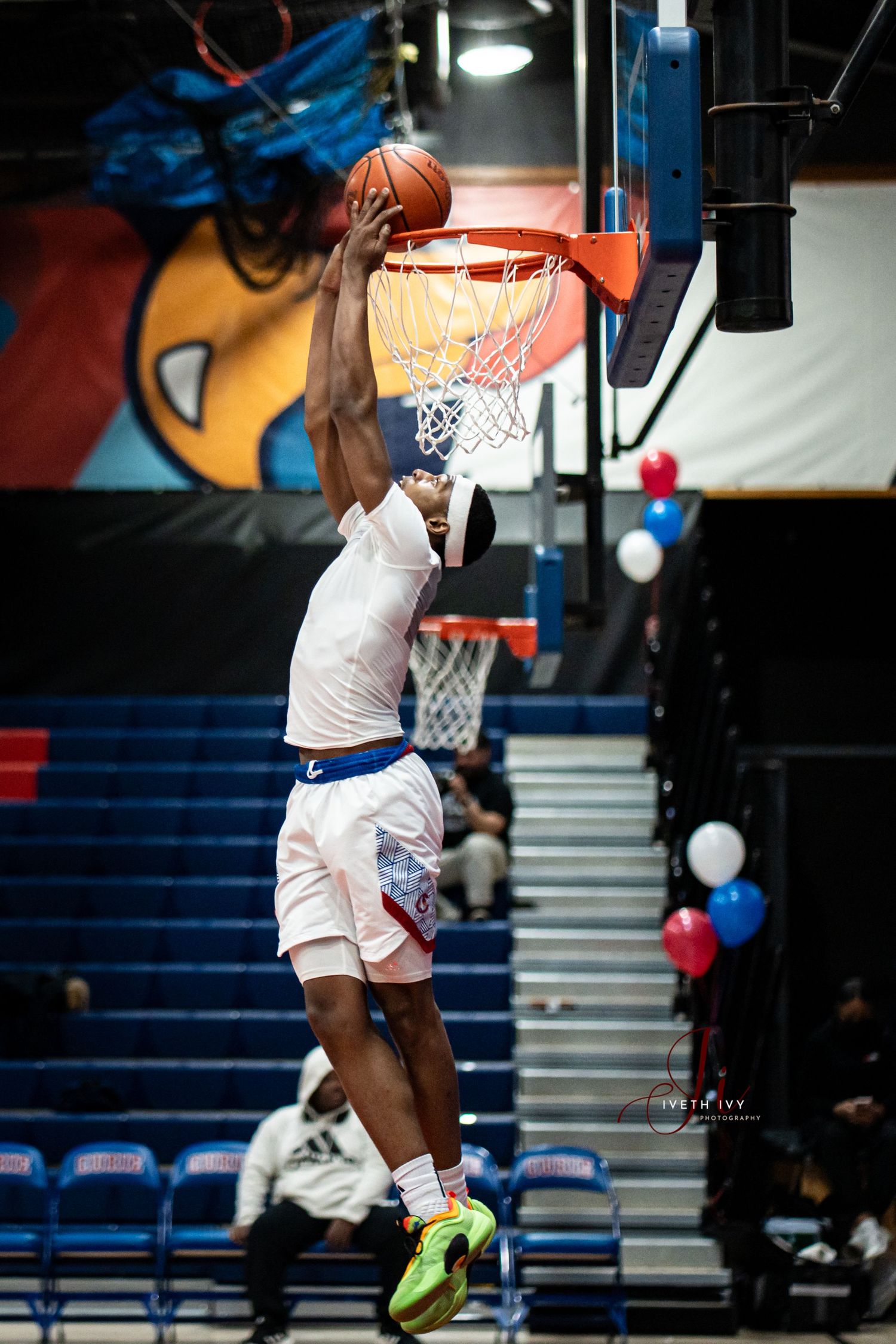 A basketball player performs a slam dunk in a dynamic sequence showing multiple stages of the jump and motion.