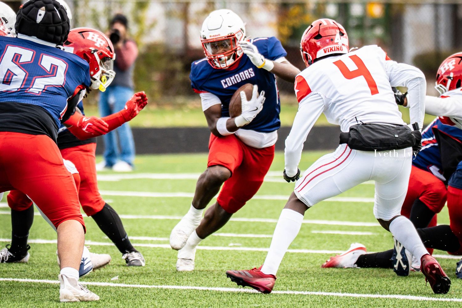 Football players engage in a tackle during a competitive game on the field.