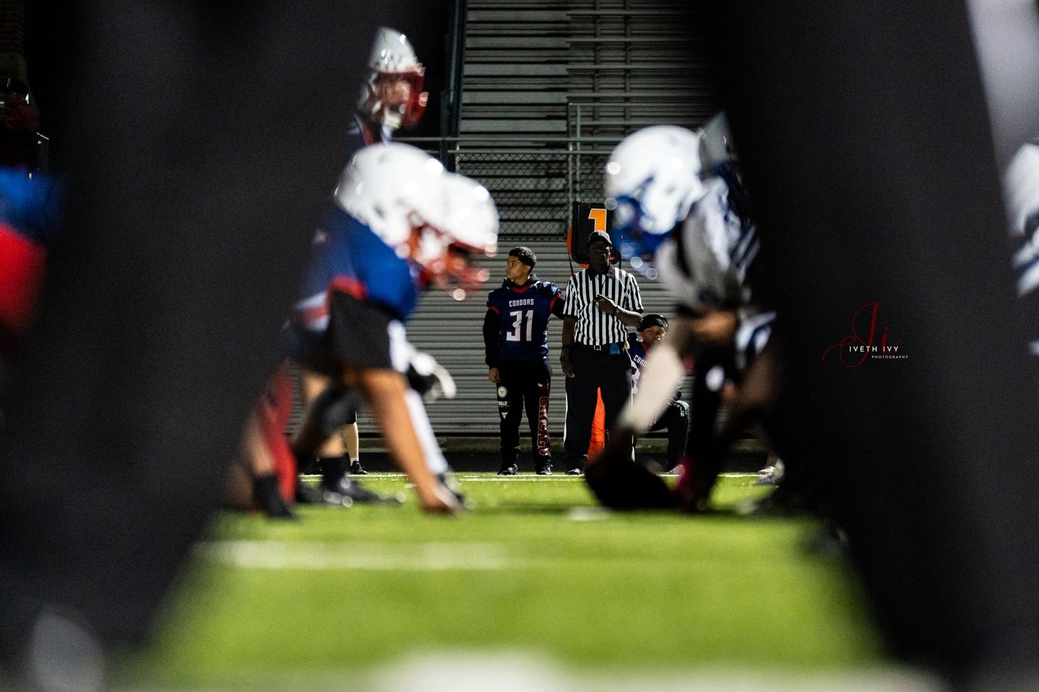 Athletes huddle on a football field during a practice session or game.