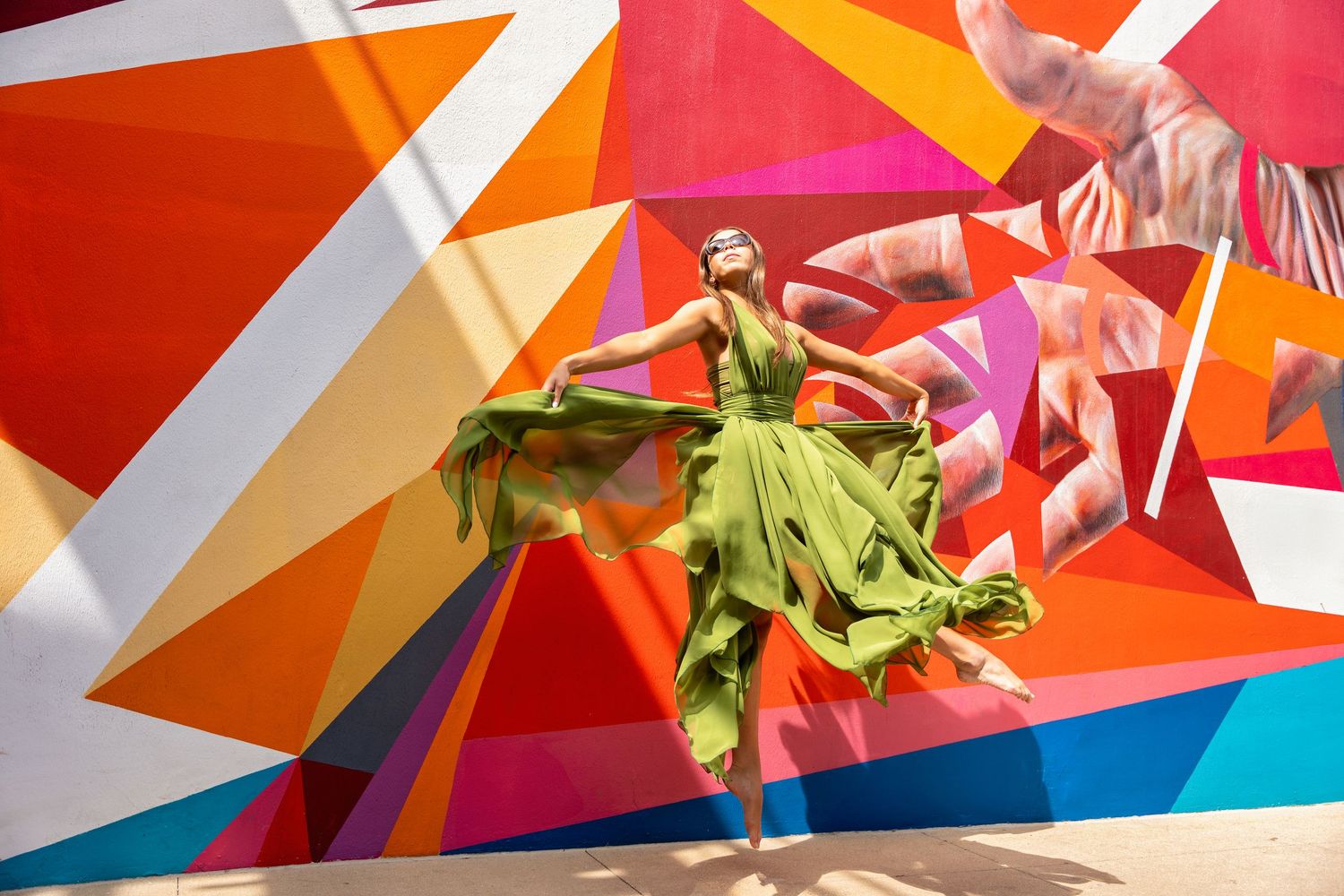 Dynamic dance photography against colorful geometric wall art.