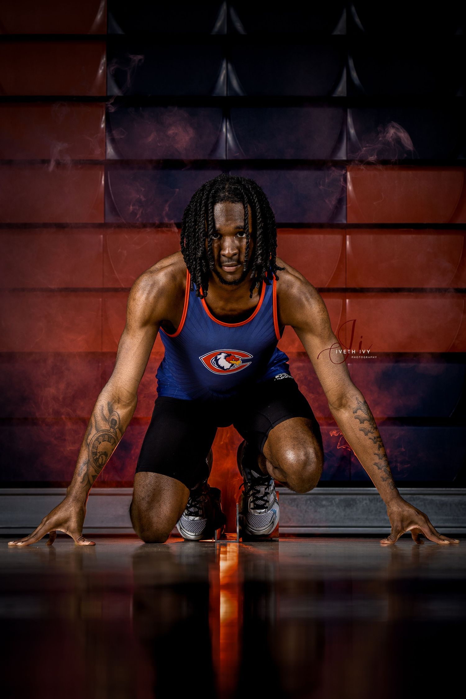 Athletic figure in blue and red workout gear performs dynamic push-up sequence on dark floor with dramatic lighting.