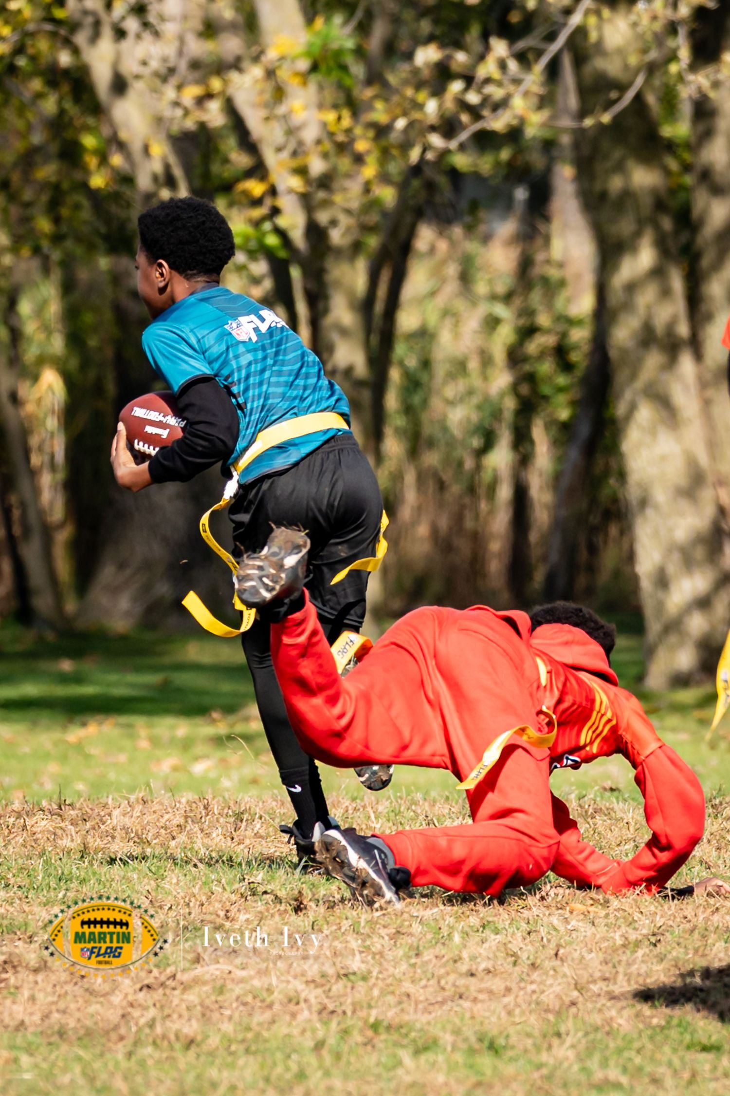 A sequence of action shots showing two players in a football tackle with one in red and one in blue uniforms on autumn leaves.