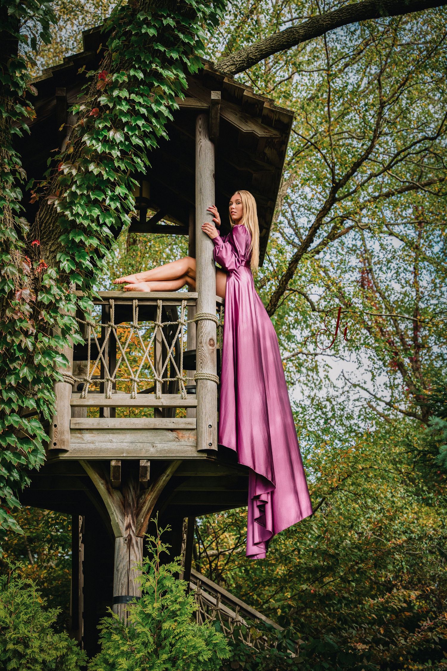 Pink flowing dress draped elegantly from a whimsical treehouse in a lush garden setting.