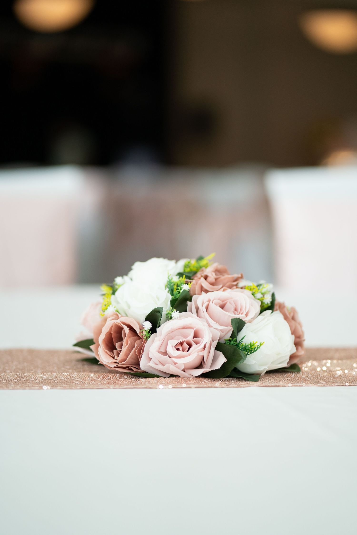 Elegant arrangement of pink and white roses on light surface with soft focus background.