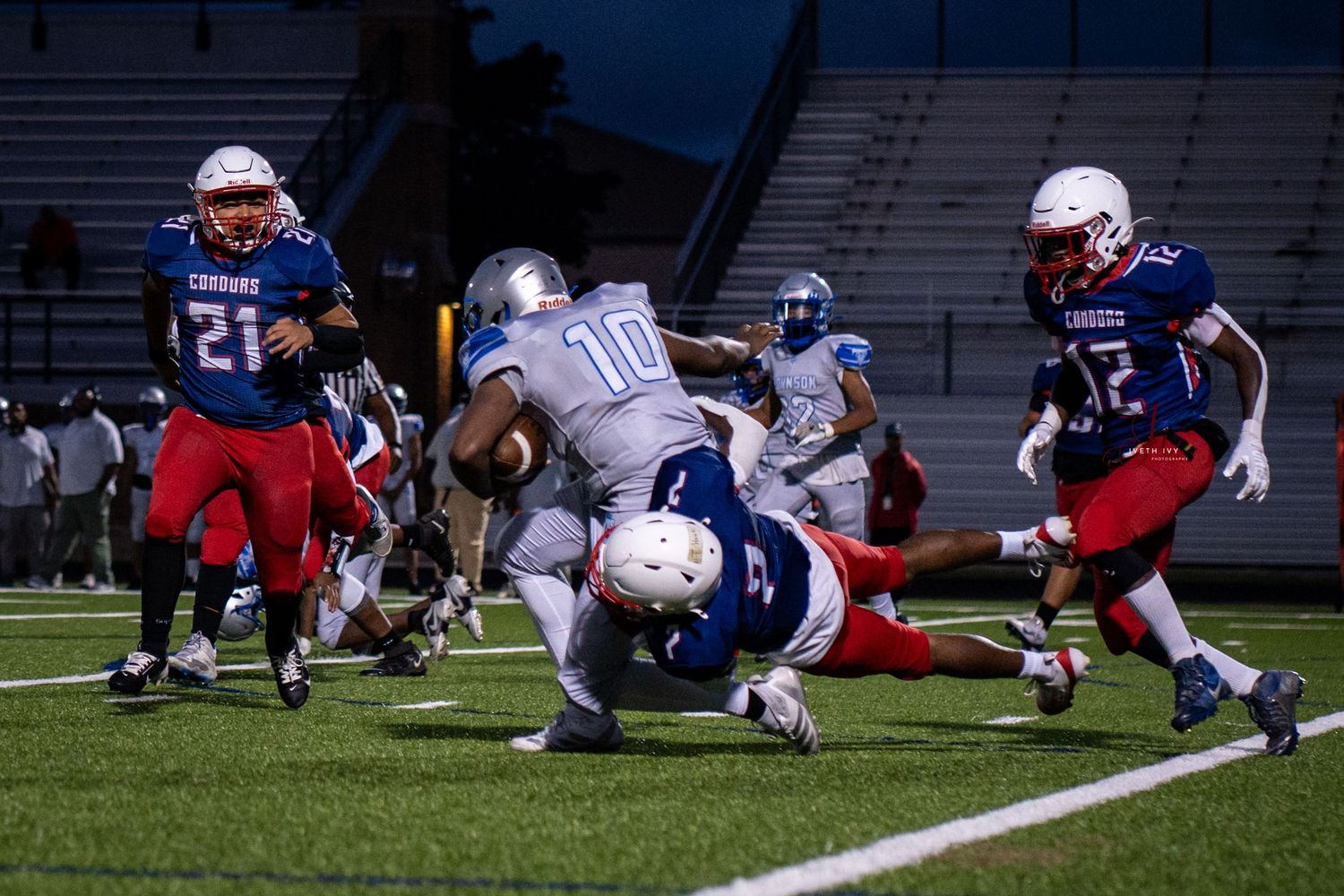Football players collide during a tackle sequence showing multiple action frames of a defensive play on the field.