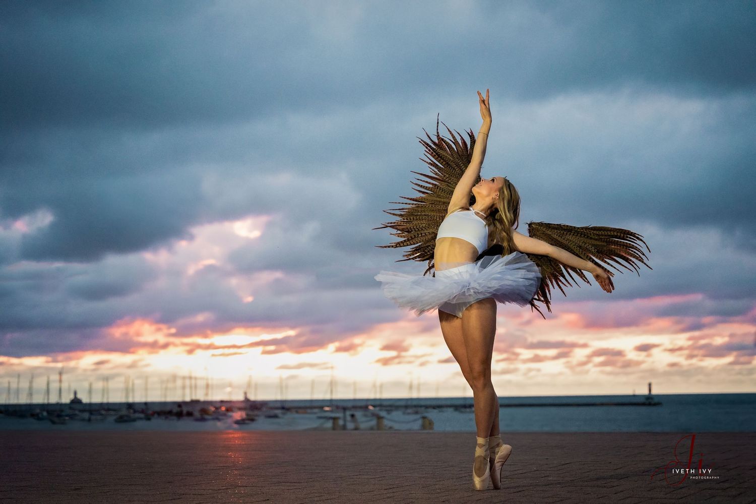 Dance silhouettes against dramatic sunset sky at beach.