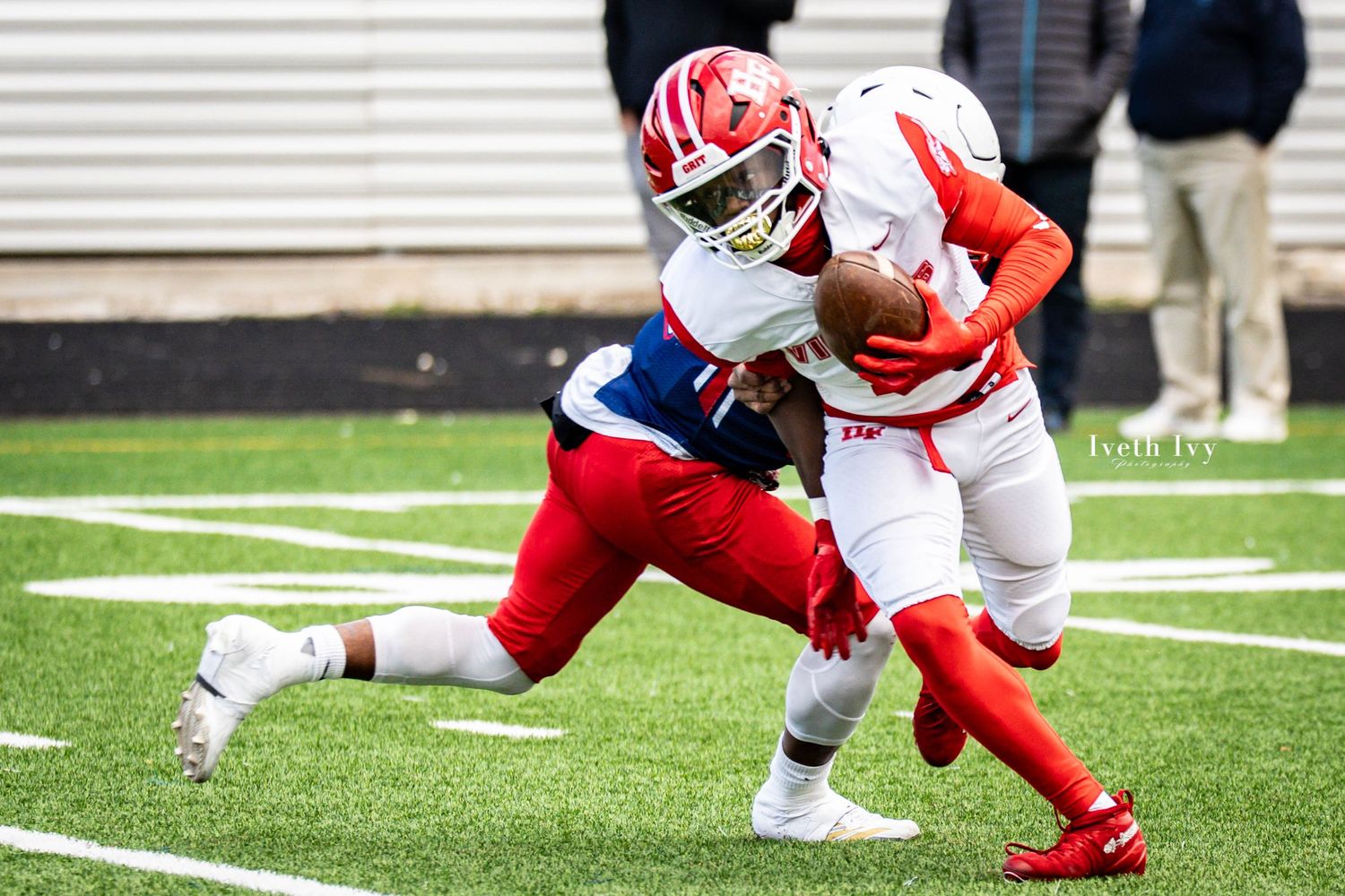 Football players in red and white uniforms engage in an intense play on the field during a game.