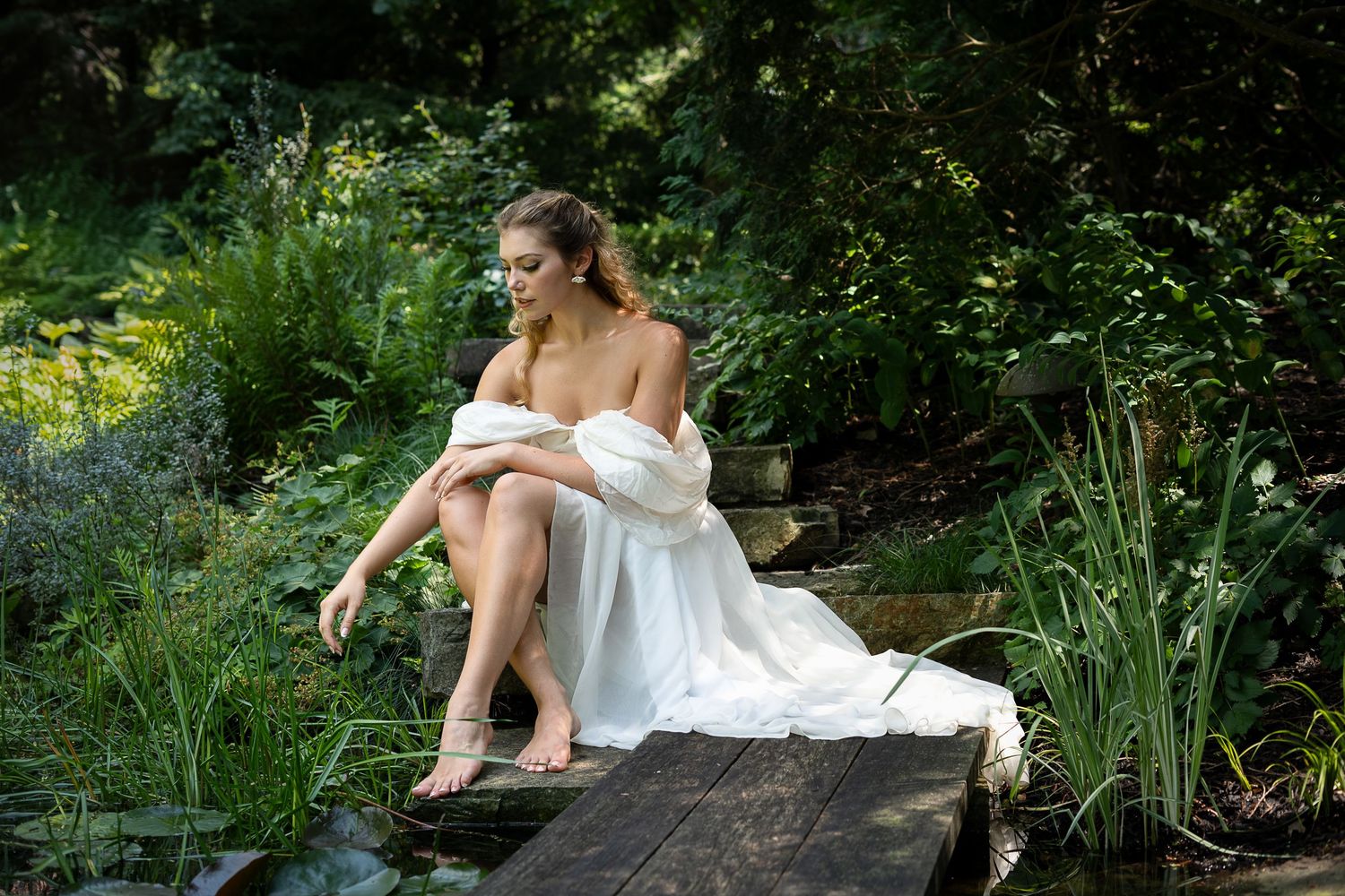 An elegant white dress contrasting with natural garden surroundings in summer.