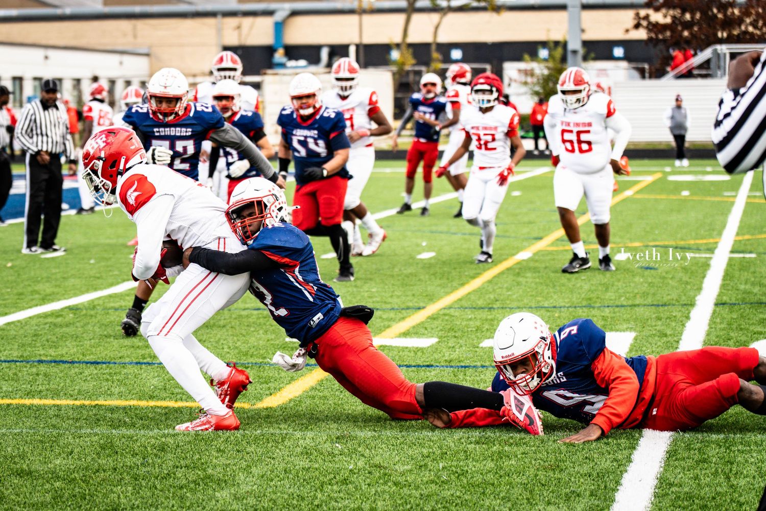 Football players from two teams clash on the field during a dynamic rushing play.