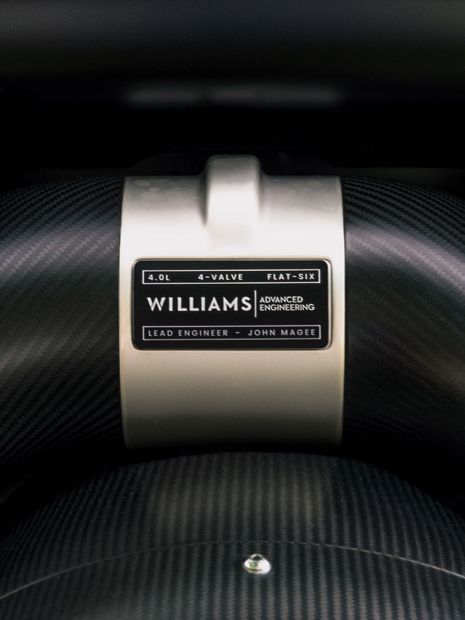 Close-up of a Williams performance part label on carbon fiber background.