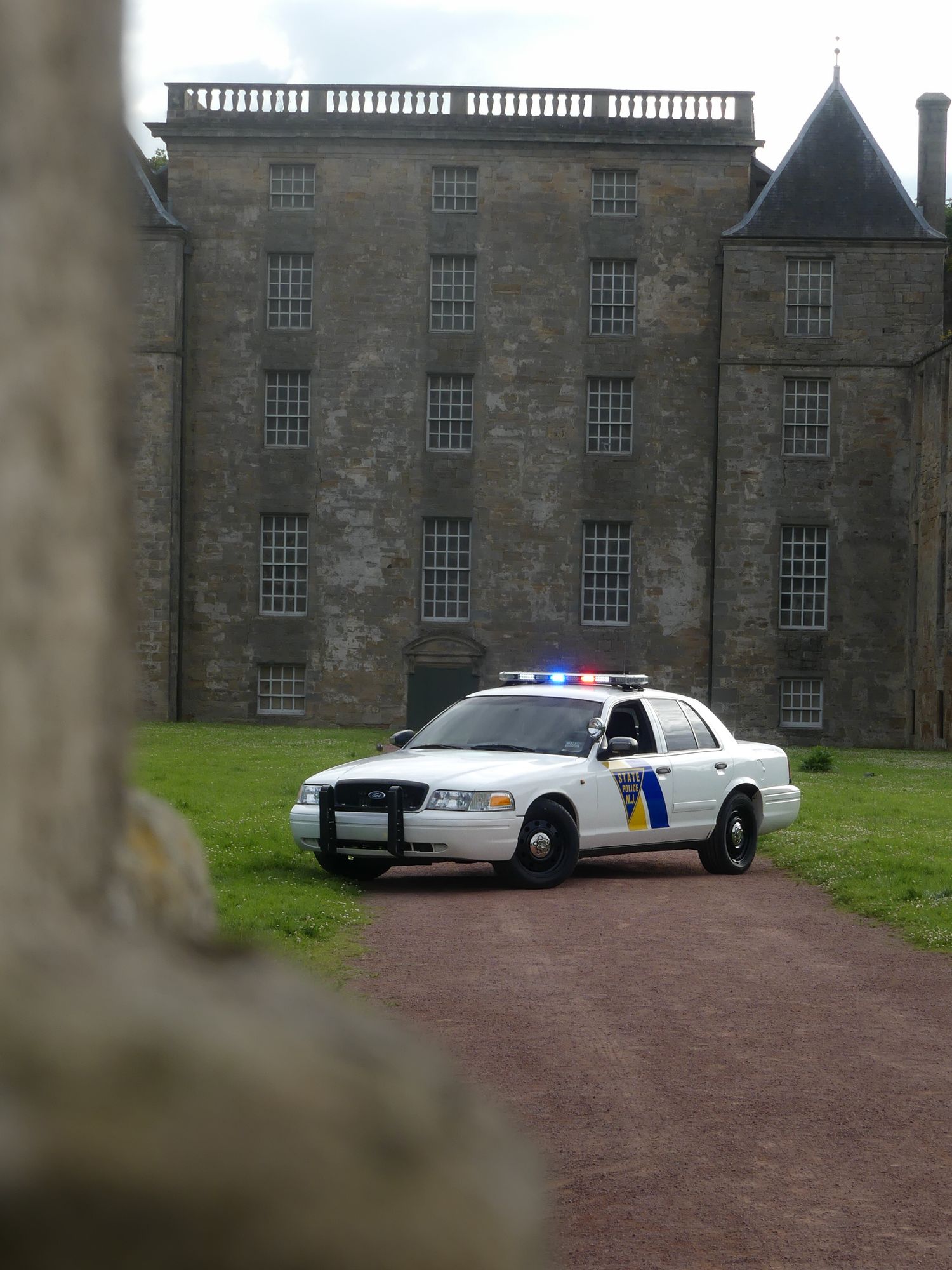 Police patrol car positioned in front of a grand Scottish stone castle.