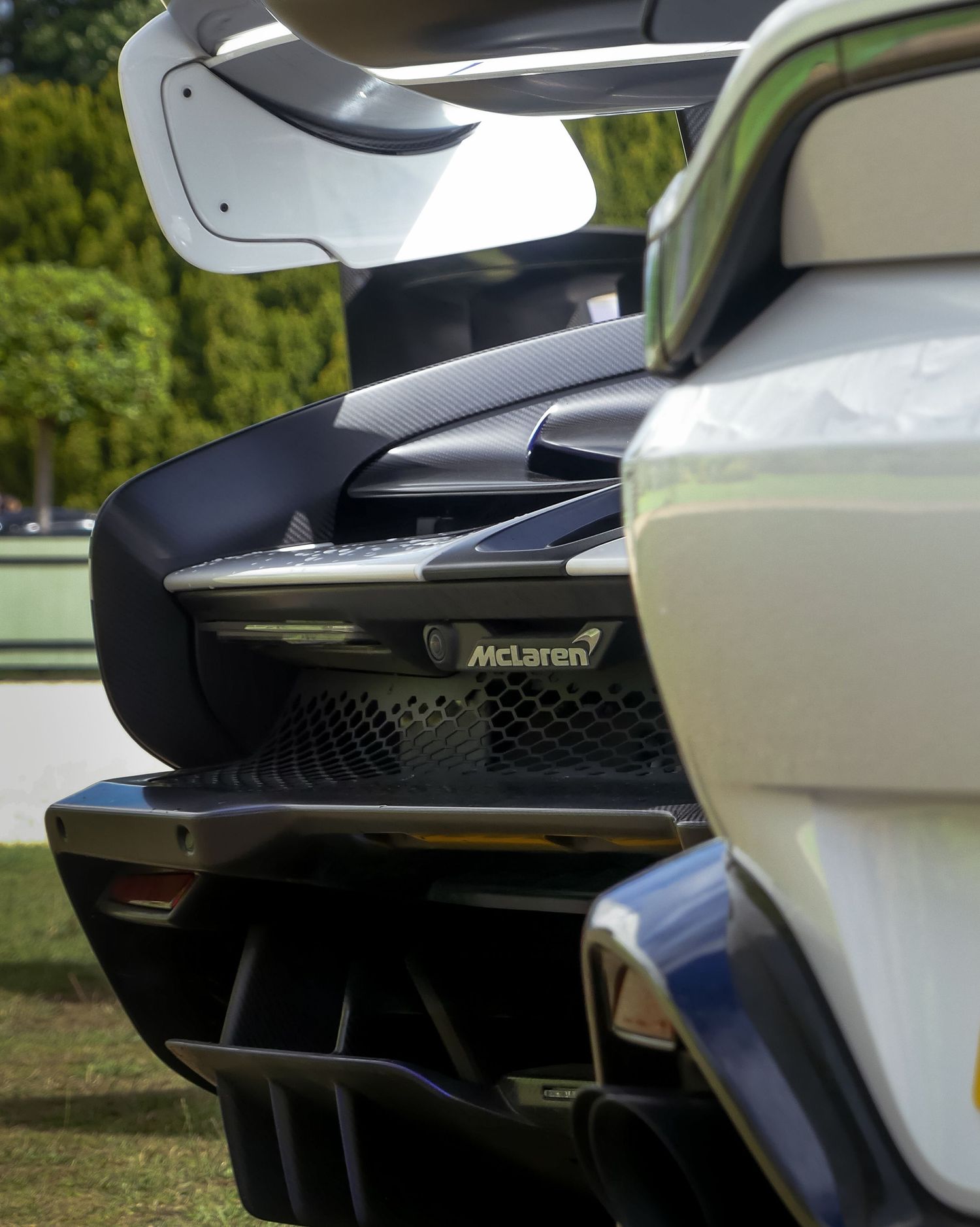 Close-up details of a McLaren supercar's sleek black and white exterior body panels and aerodynamic elements.