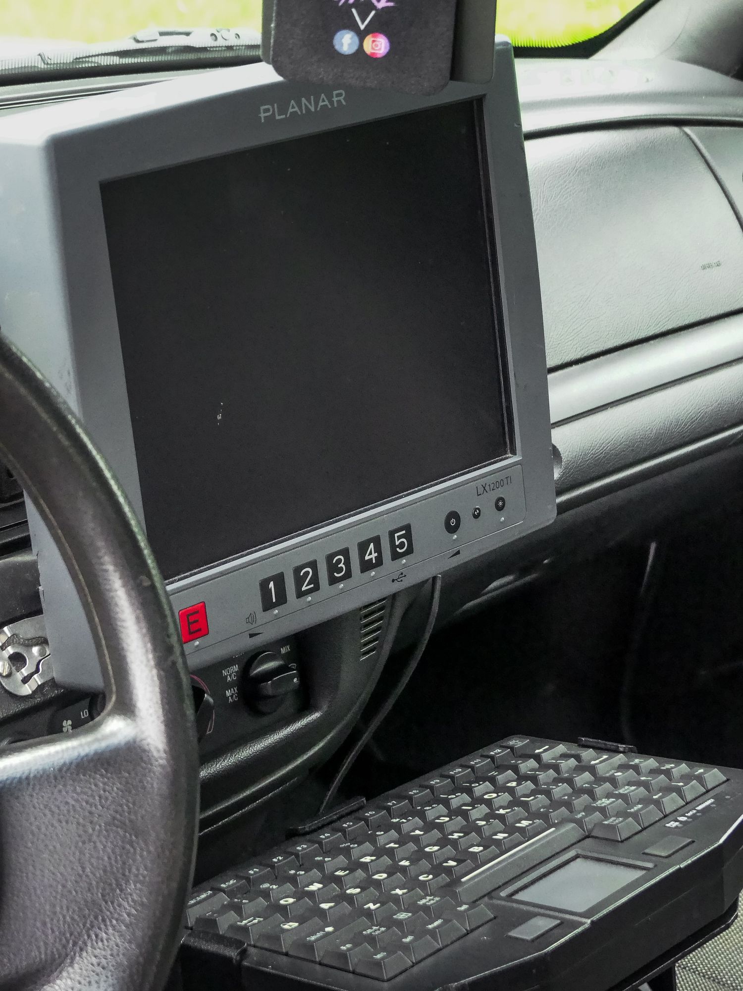 Compact LCD monitor and keyboard mounted inside police vehicle dashboard for mobile computing operations.