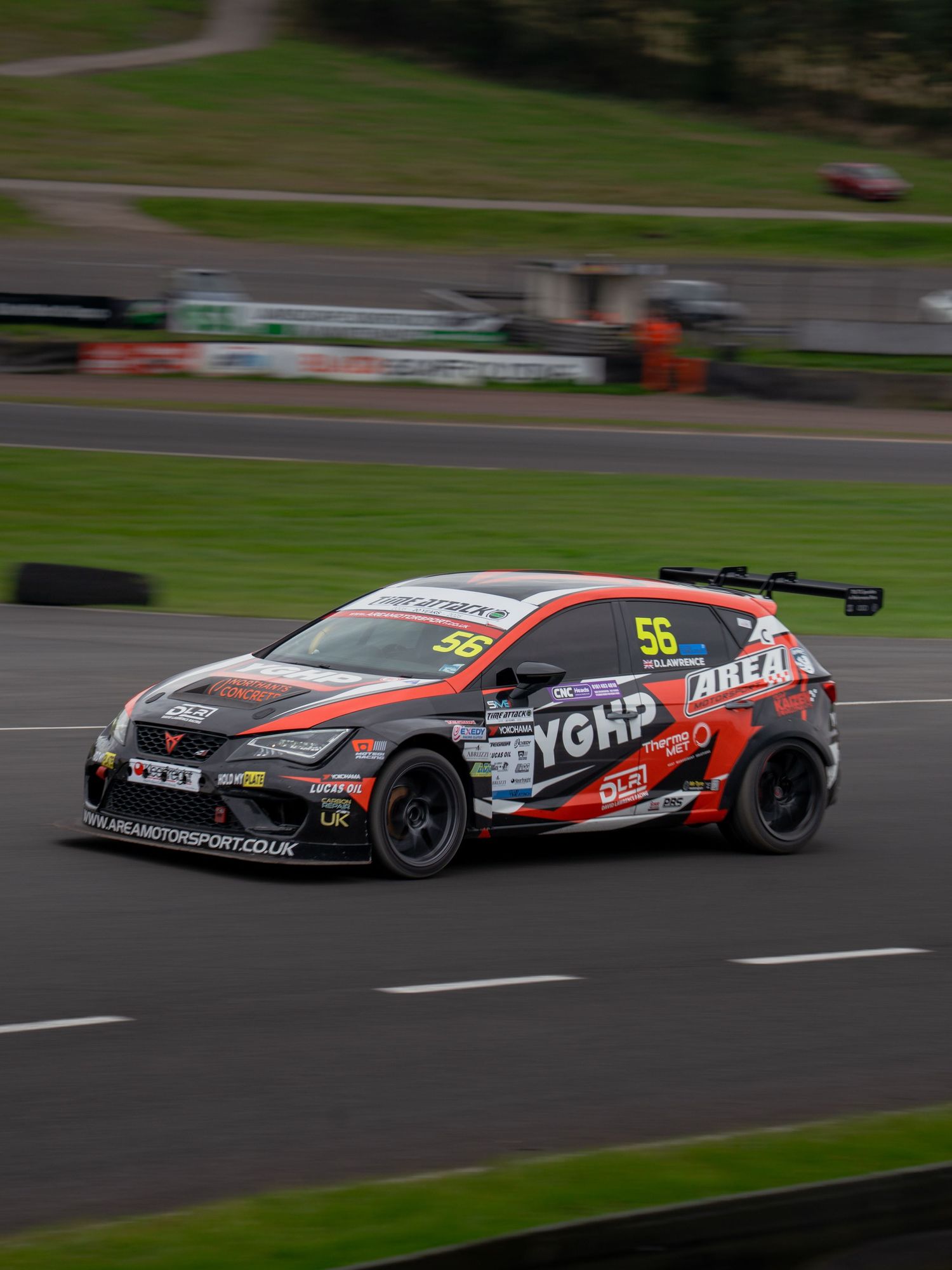 Racing car in motion on track with motion blur effect showing speed and dynamic movement during competition.