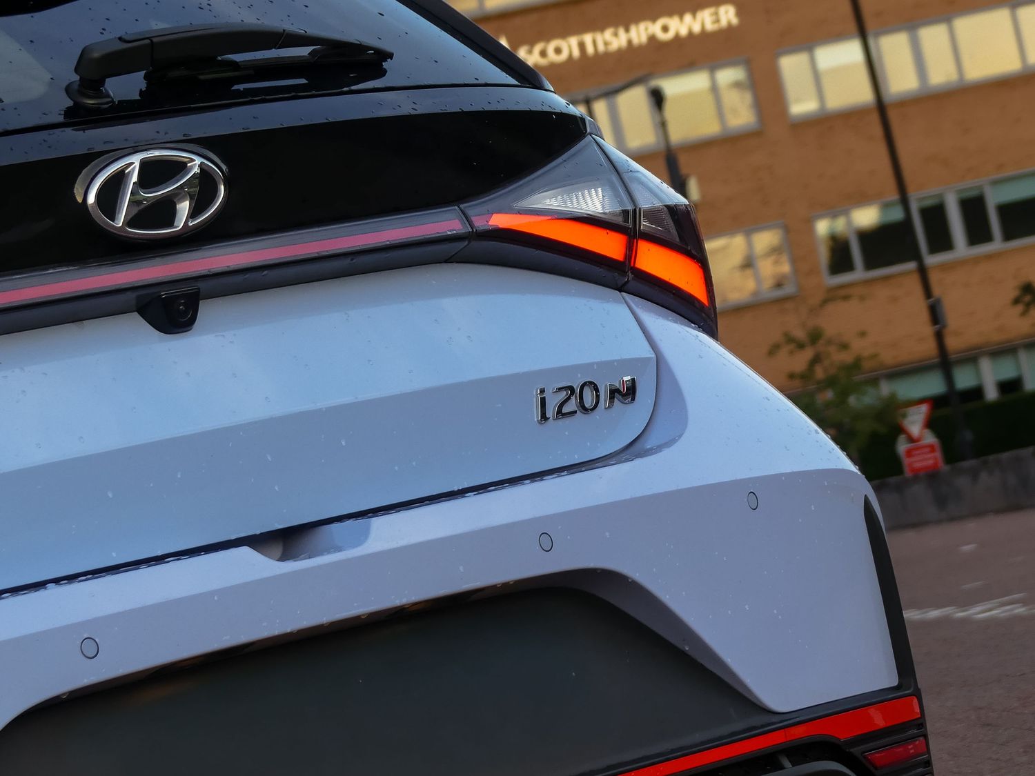 A close-up view of a Hyundai i20N performance car's rear end showing distinctive taillight and spoiler design.