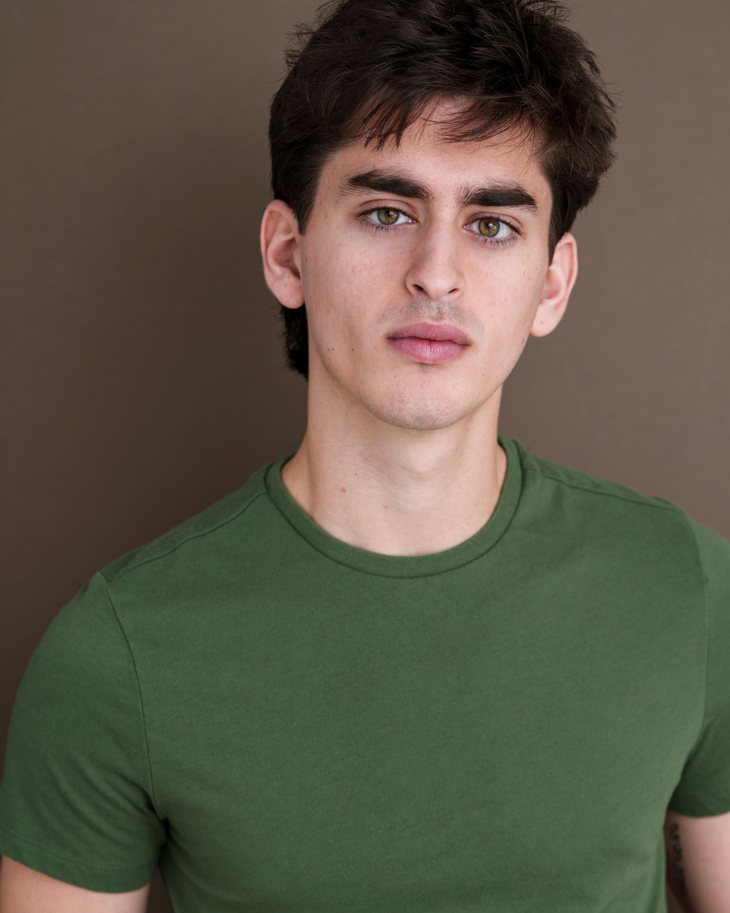 Portrait series showing various expressions while wearing a green t-shirt.