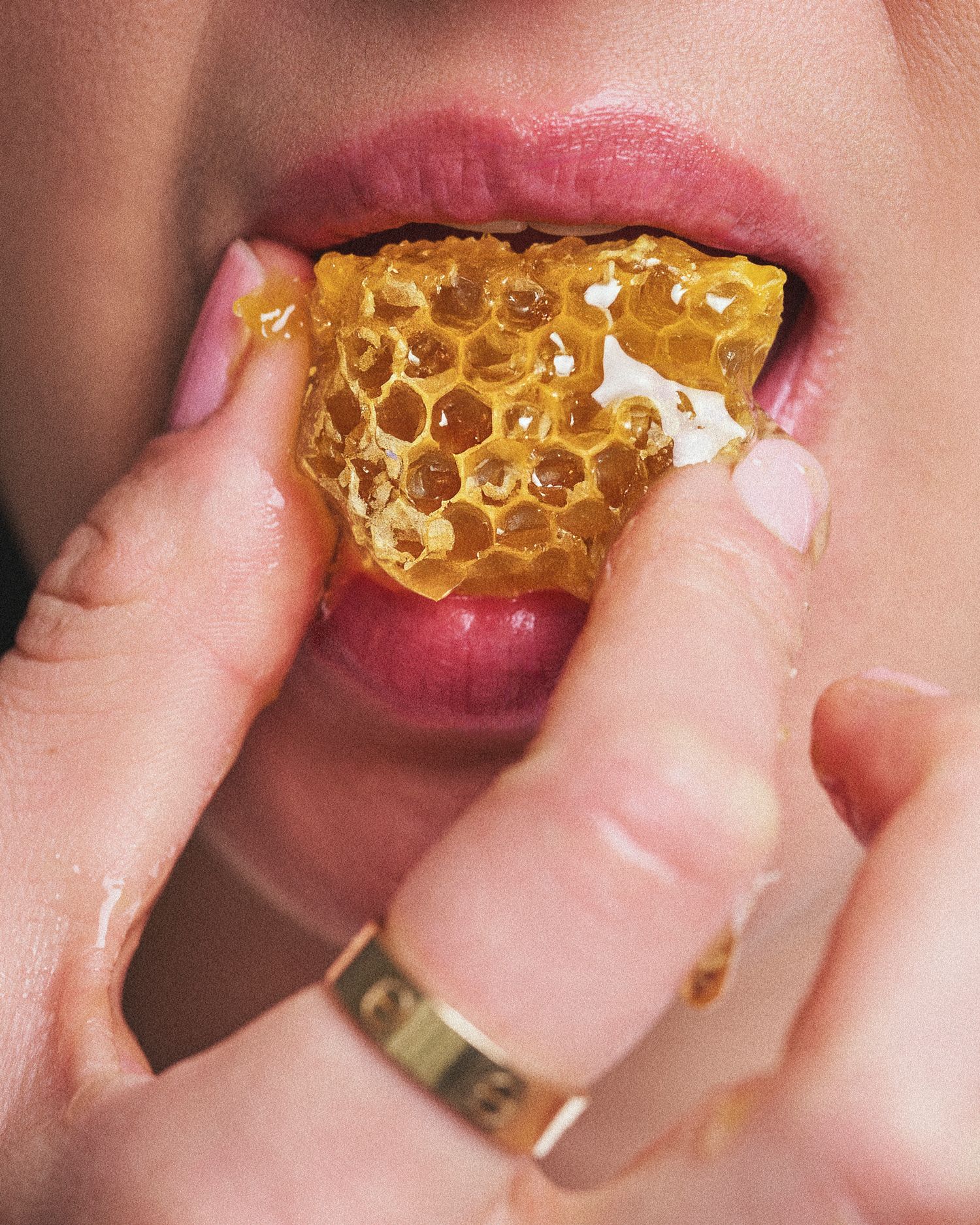 Lindy Lin's close up shot for Beekeeper's Naturals showing someone eating a piece of honeycomb with golden honey dripping