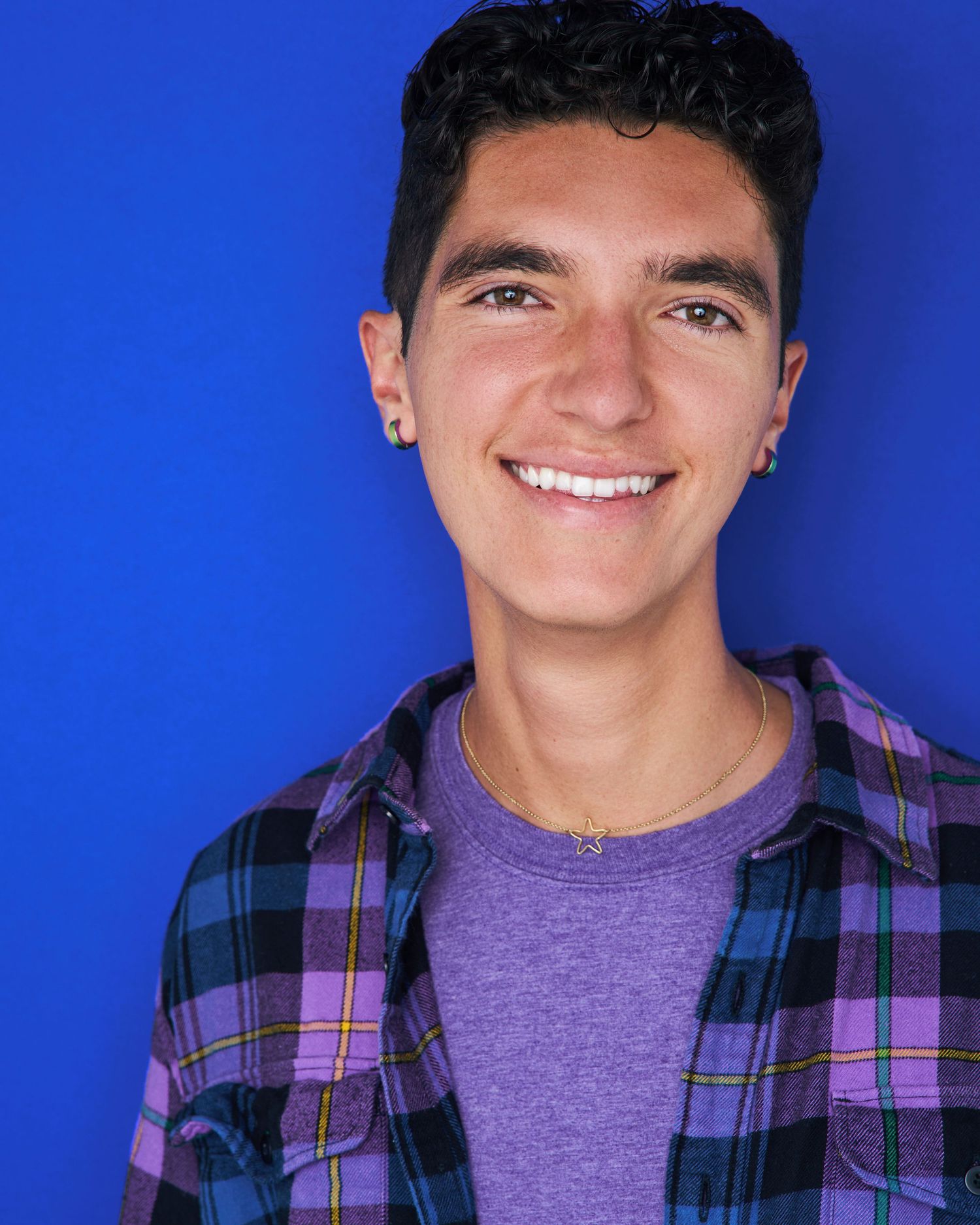 Headshot series against blue background showing person in plaid shirt and purple t-shirt.