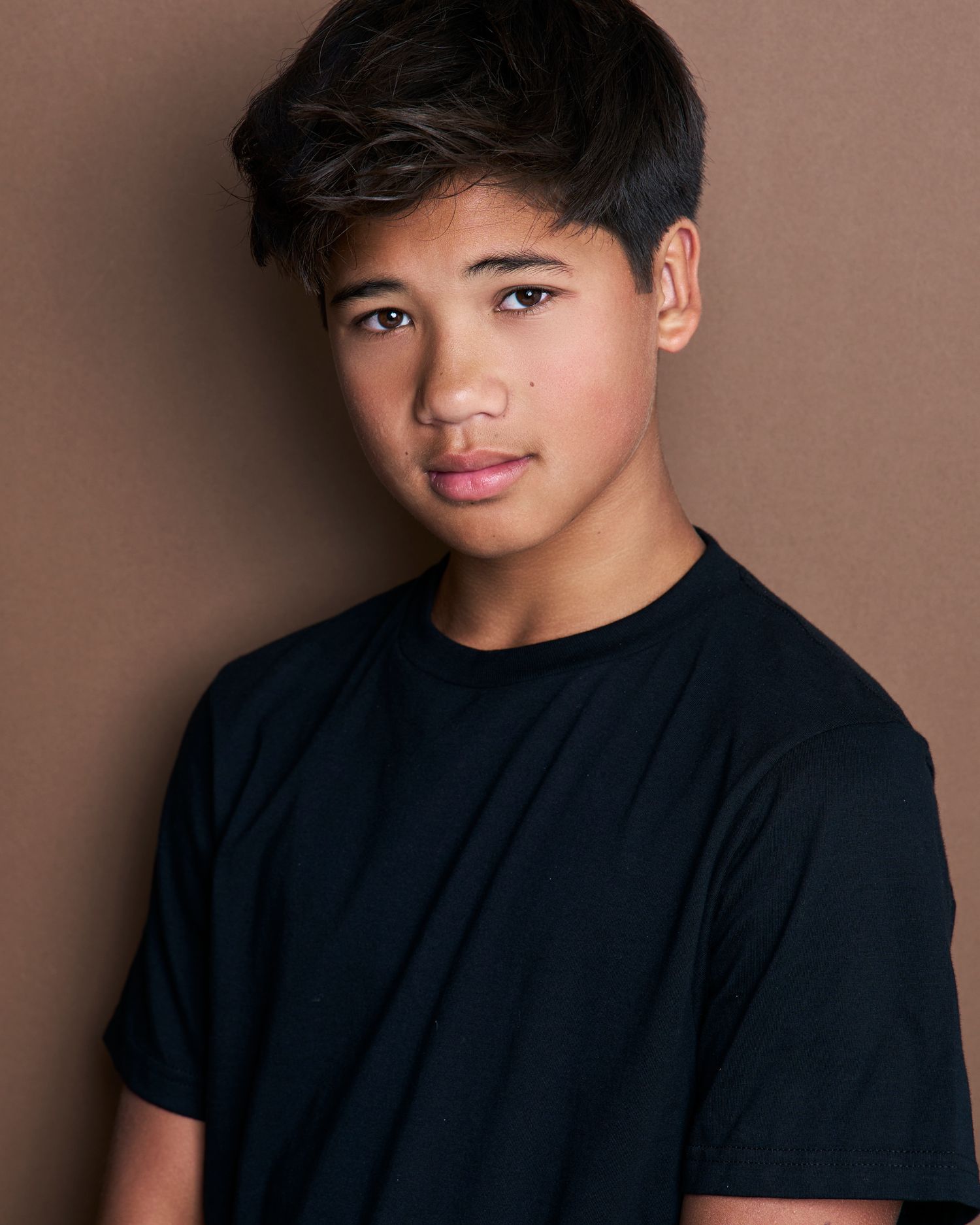 Casual headshot series of young person in black t-shirt against neutral backdrop.