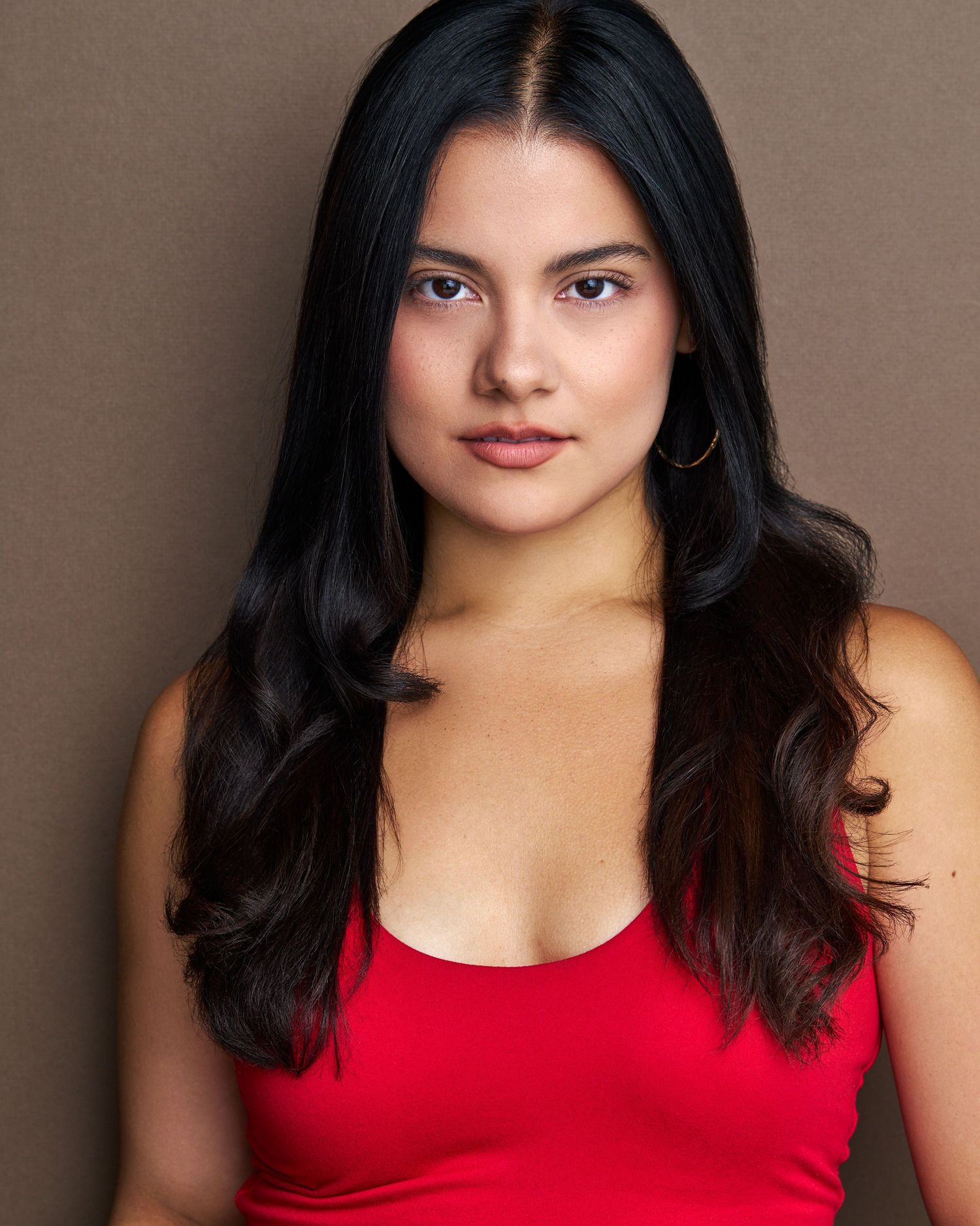 Model in a red tank top poses for a series of professional portraits against a neutral background.