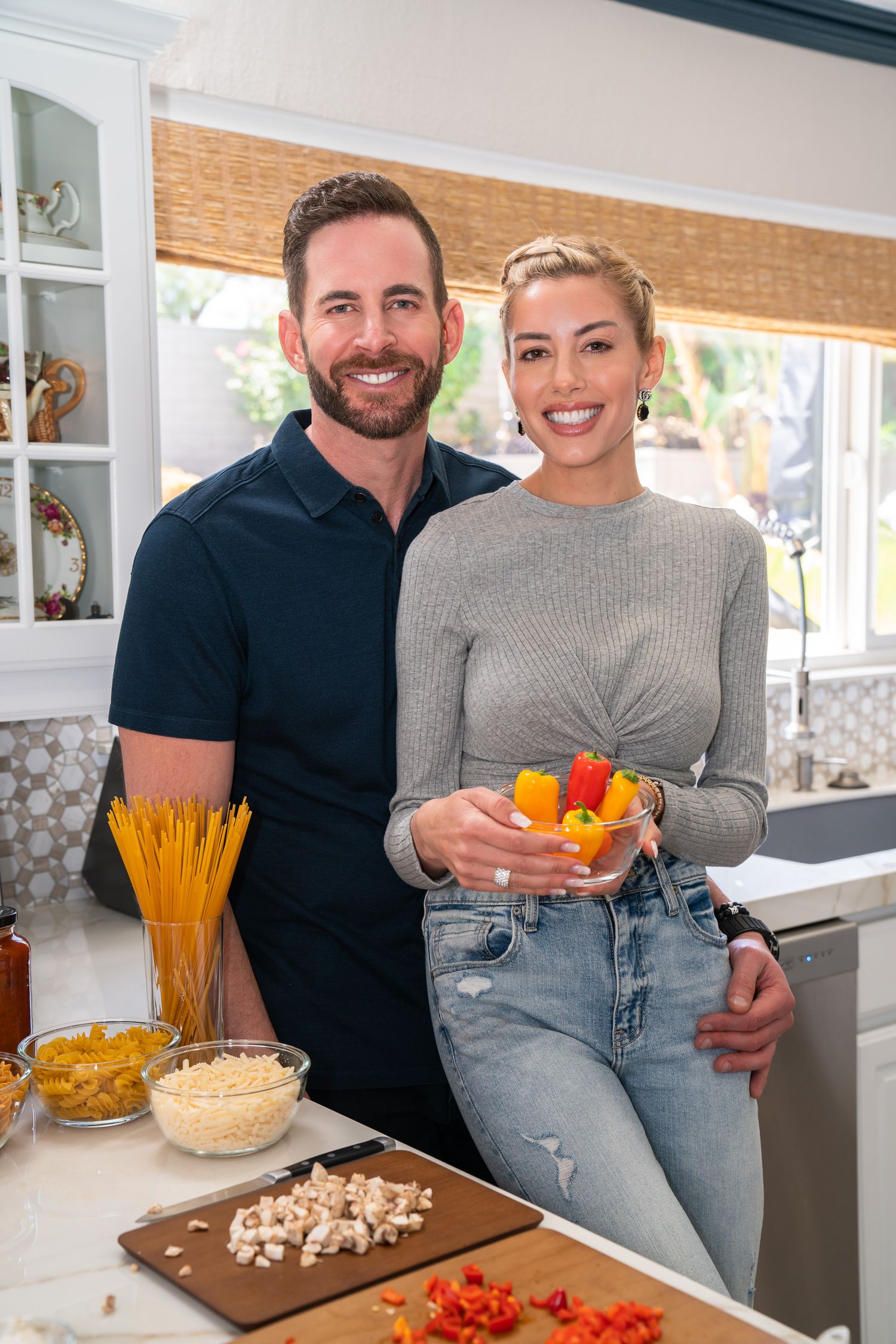 Tarek El Moussa and Heather Rae El Moussa in the kitchen preparing a meal, photographed by Lindy Li