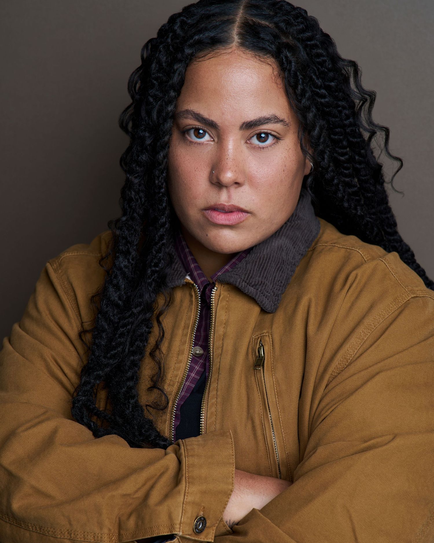 Fashion portraits featuring tan workwear jacket against dark background.