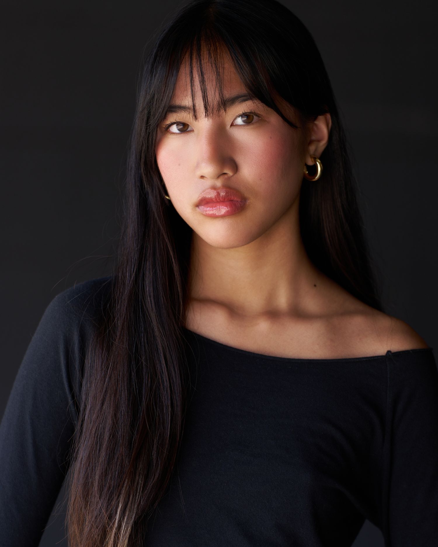 Dramatic dark lighting portrait series showing someone in a black top.