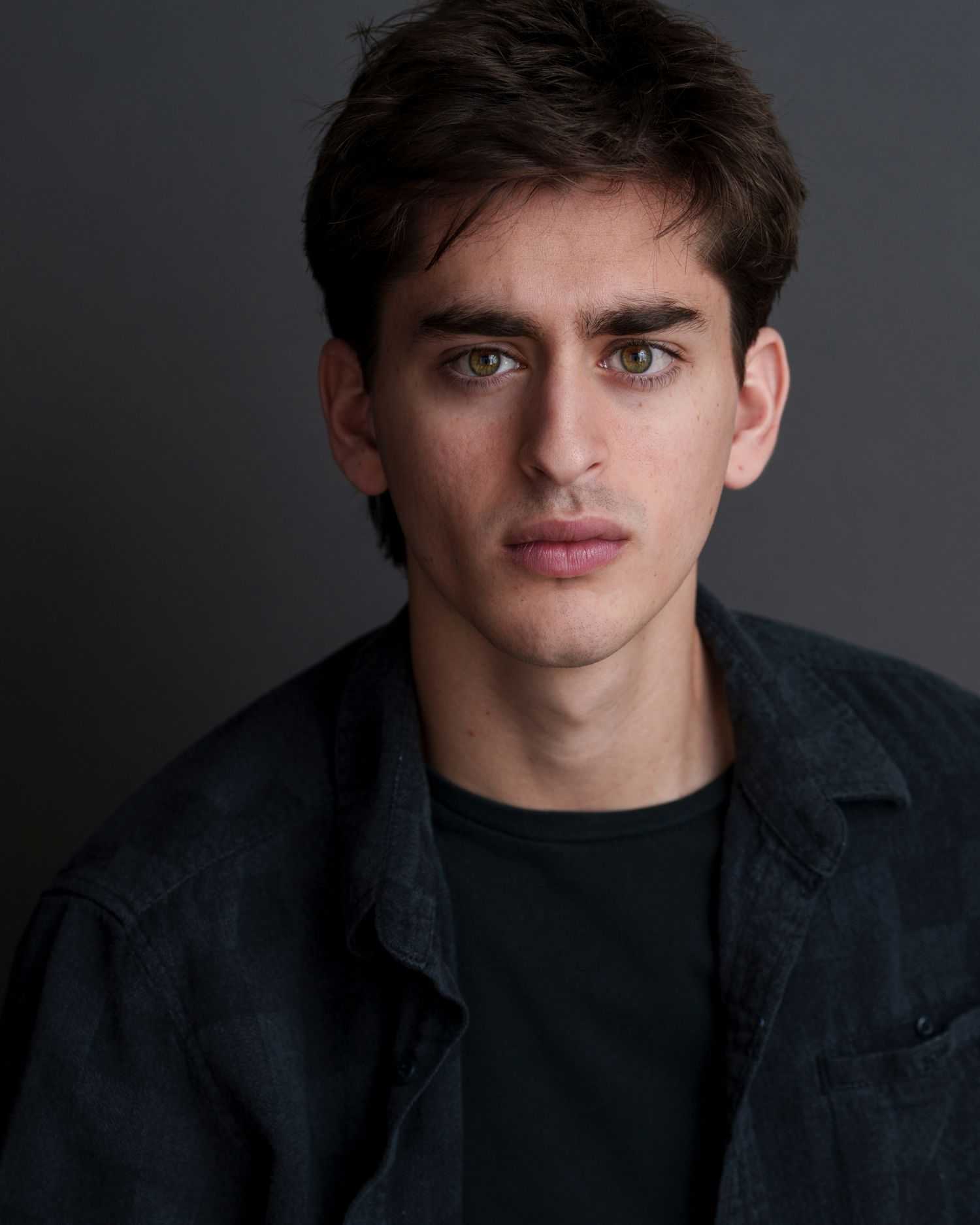 Moody portrait series against dark background wearing black clothing.