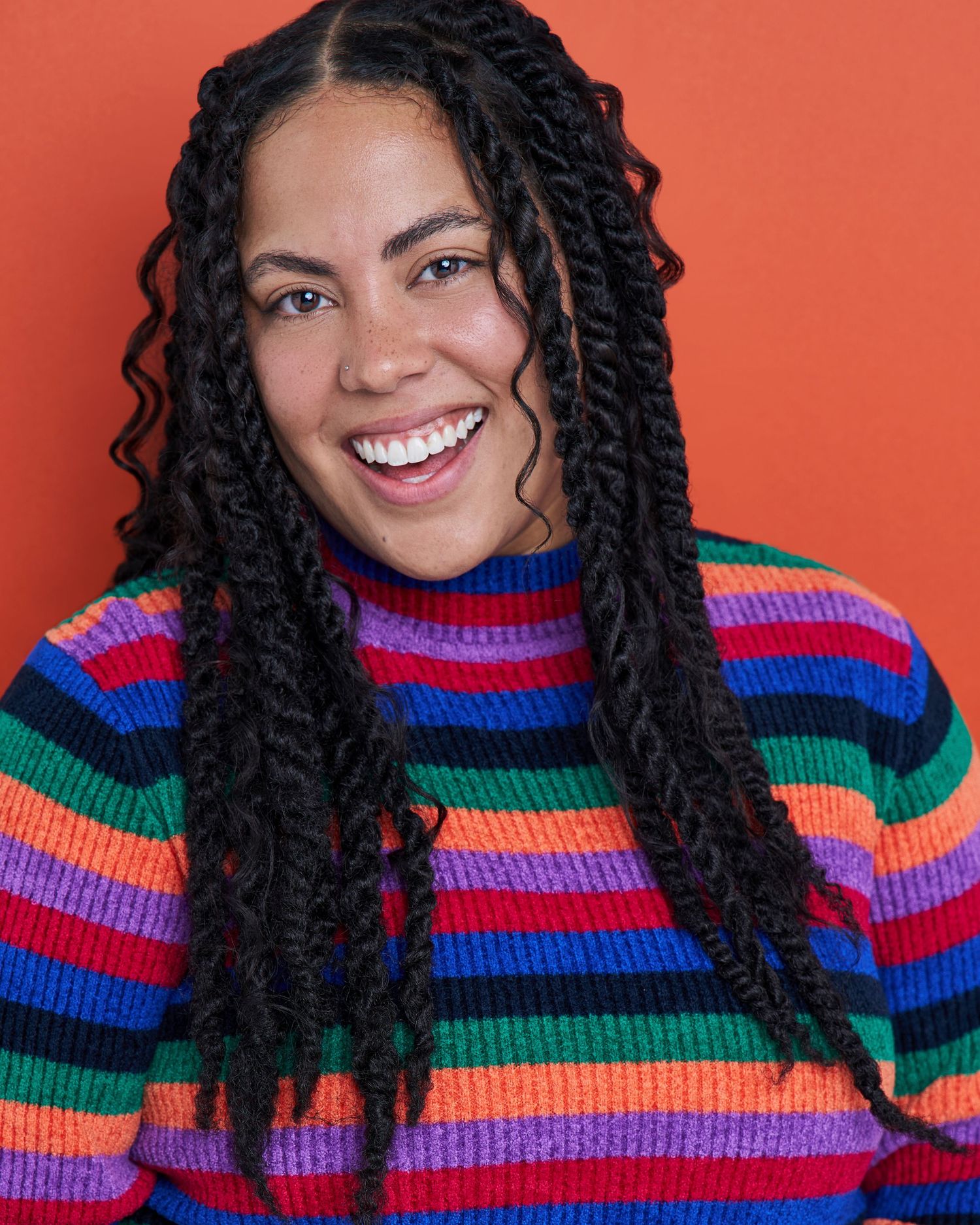 Colorful portrait series featuring vibrant striped turtleneck sweater against orange background.
