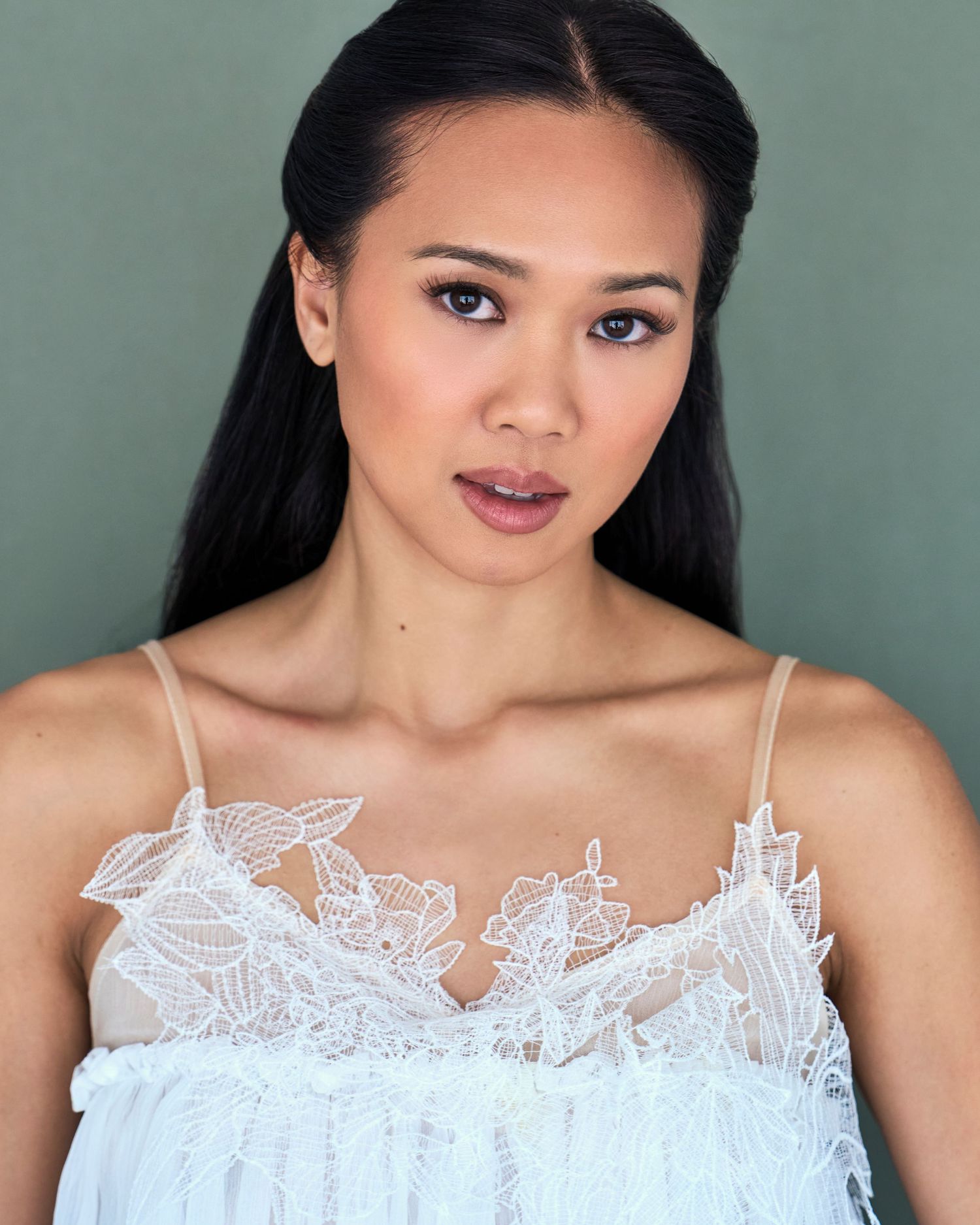 Elegant portrait series in white lace top against sage green background.