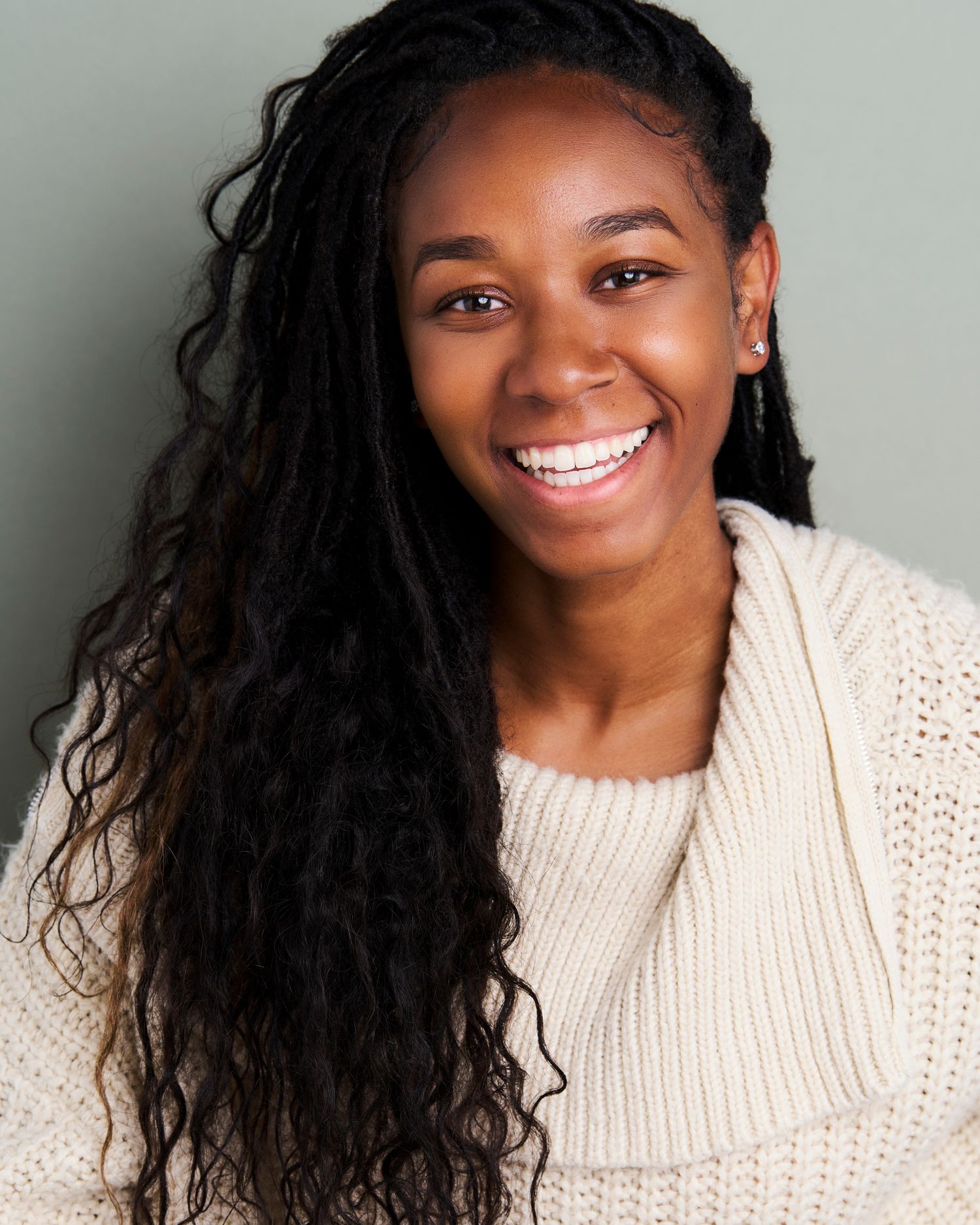 Series of joyful expressions in a cream sweater against a light gray background.