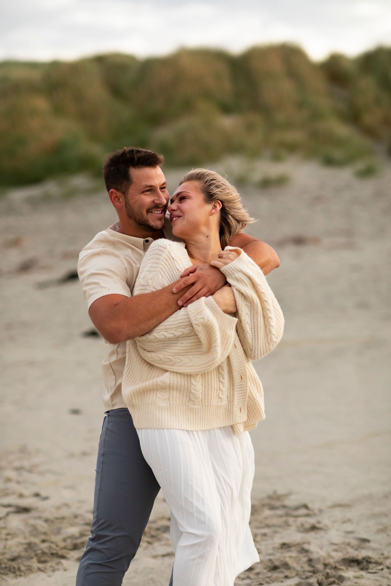 vacation photo of couple on beach in New Zealand happy