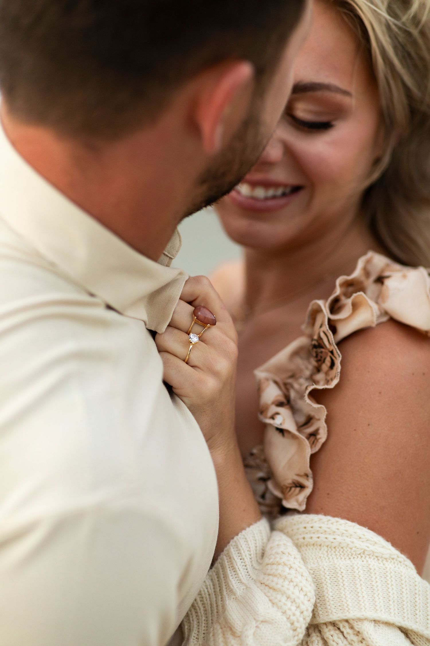 Intimate close-up of a couple sharing a tender moment in cream-colored attire.